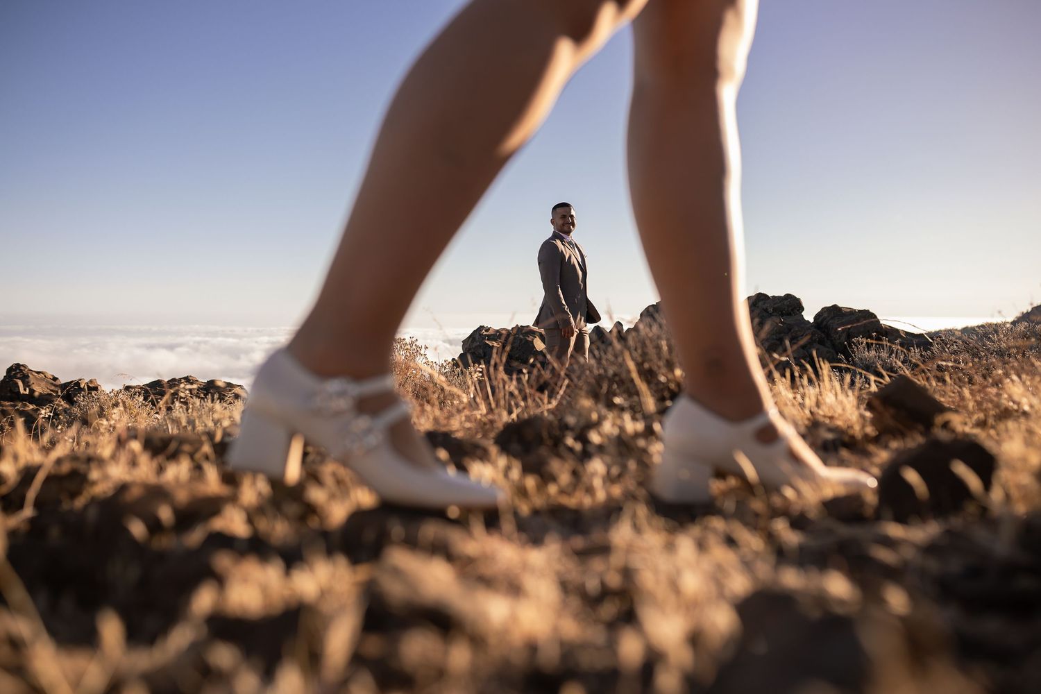 Close-up shot of feet walking on rocky terrain during a sunset photo session.