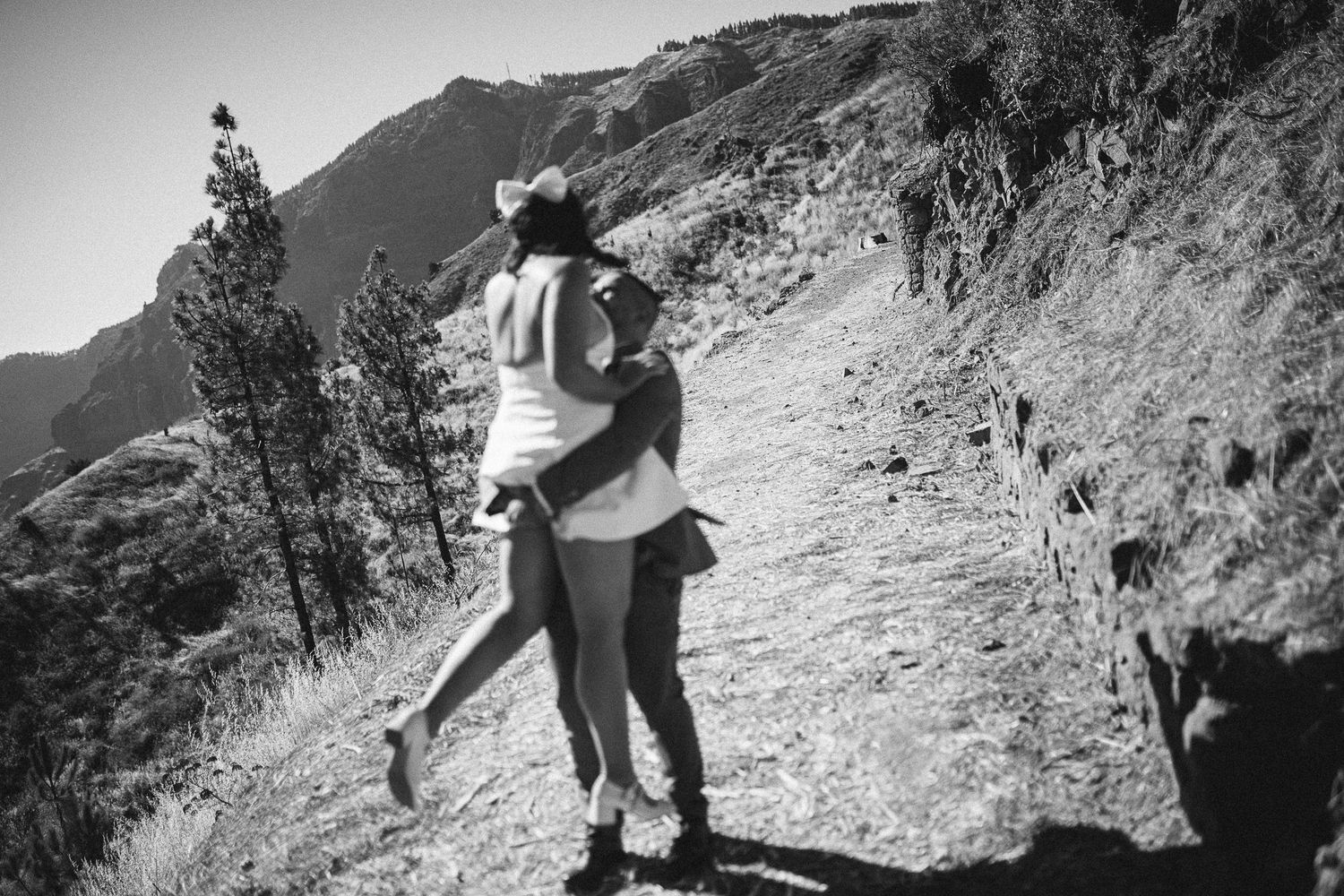 A couple explores a rugged mountain trail together.