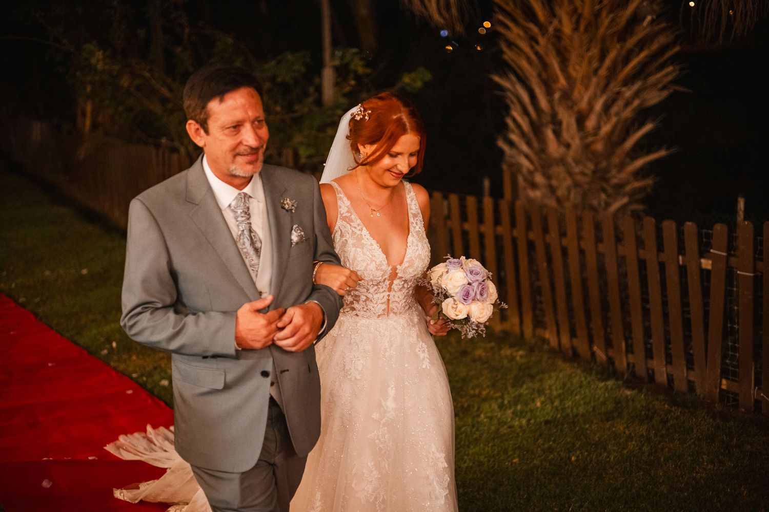 Couple shares an intimate moment under string lights on their wedding night.