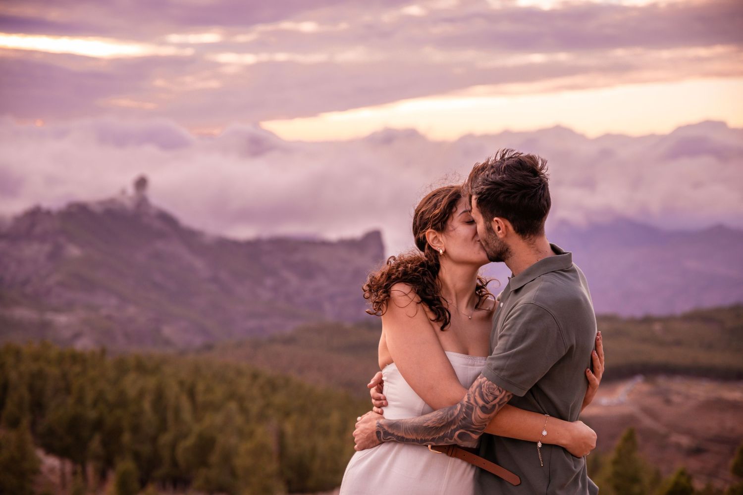 Romantic sunset photoshoot in mountains with dramatic purple sky.
