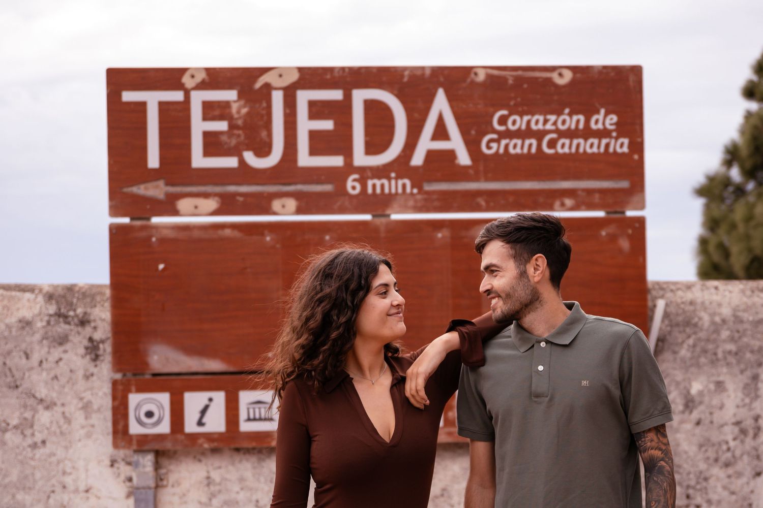 Couple sharing a joyful moment in front of the Tejeda sign in Gran Canaria.