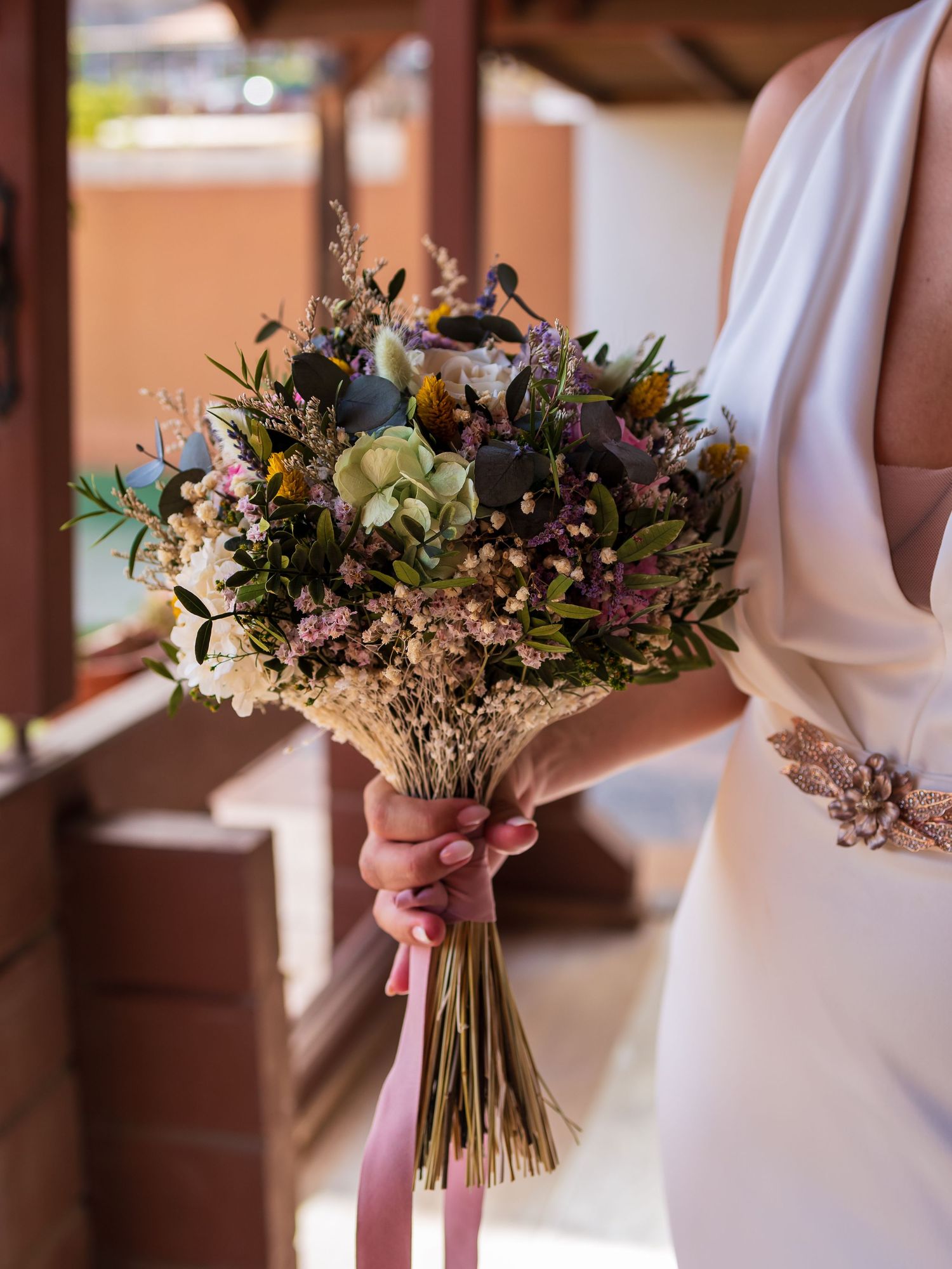 Elegant wedding bouquets with mixed flowers and dried elements in muted tones.