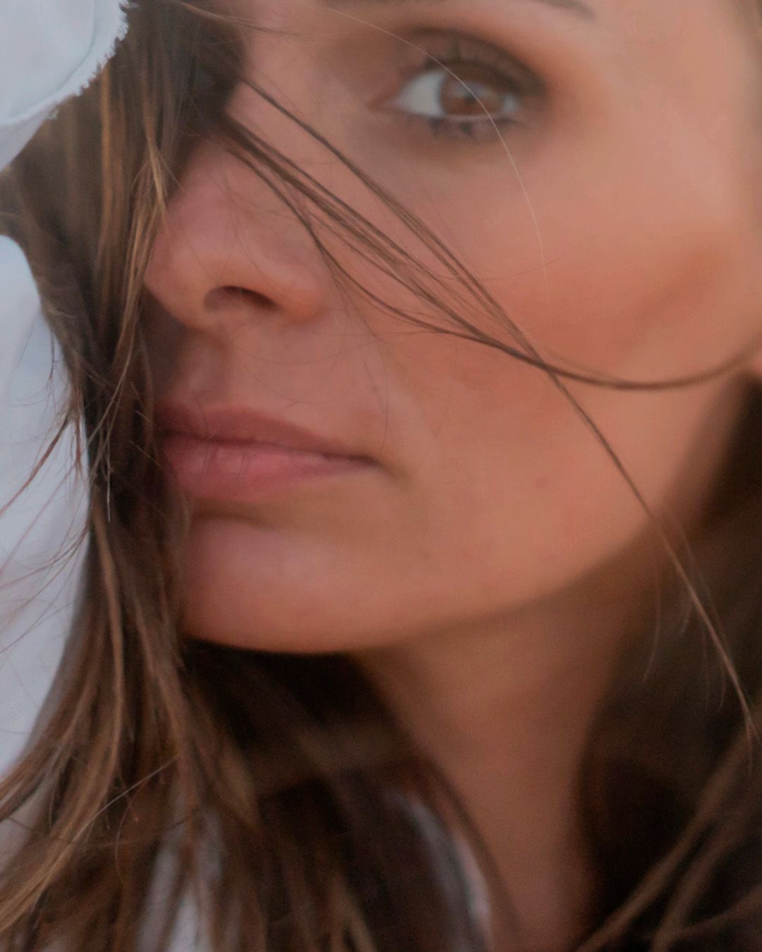 A series of close-up portraits showing windswept brown hair and partial facial features against a warm background.