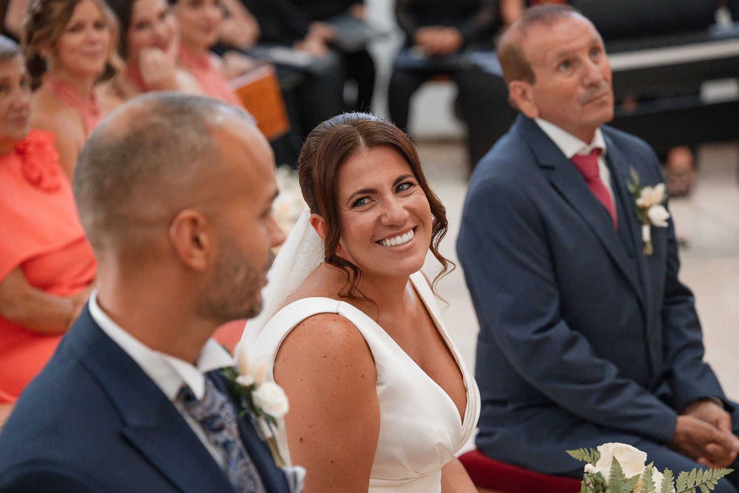 Wedding guests seated in rows during an indoor ceremony.