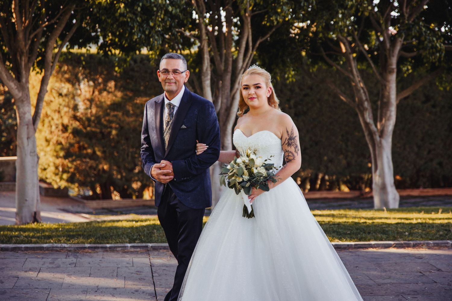 Wedding couple poses for romantic sunset portraits in an outdoor garden setting.