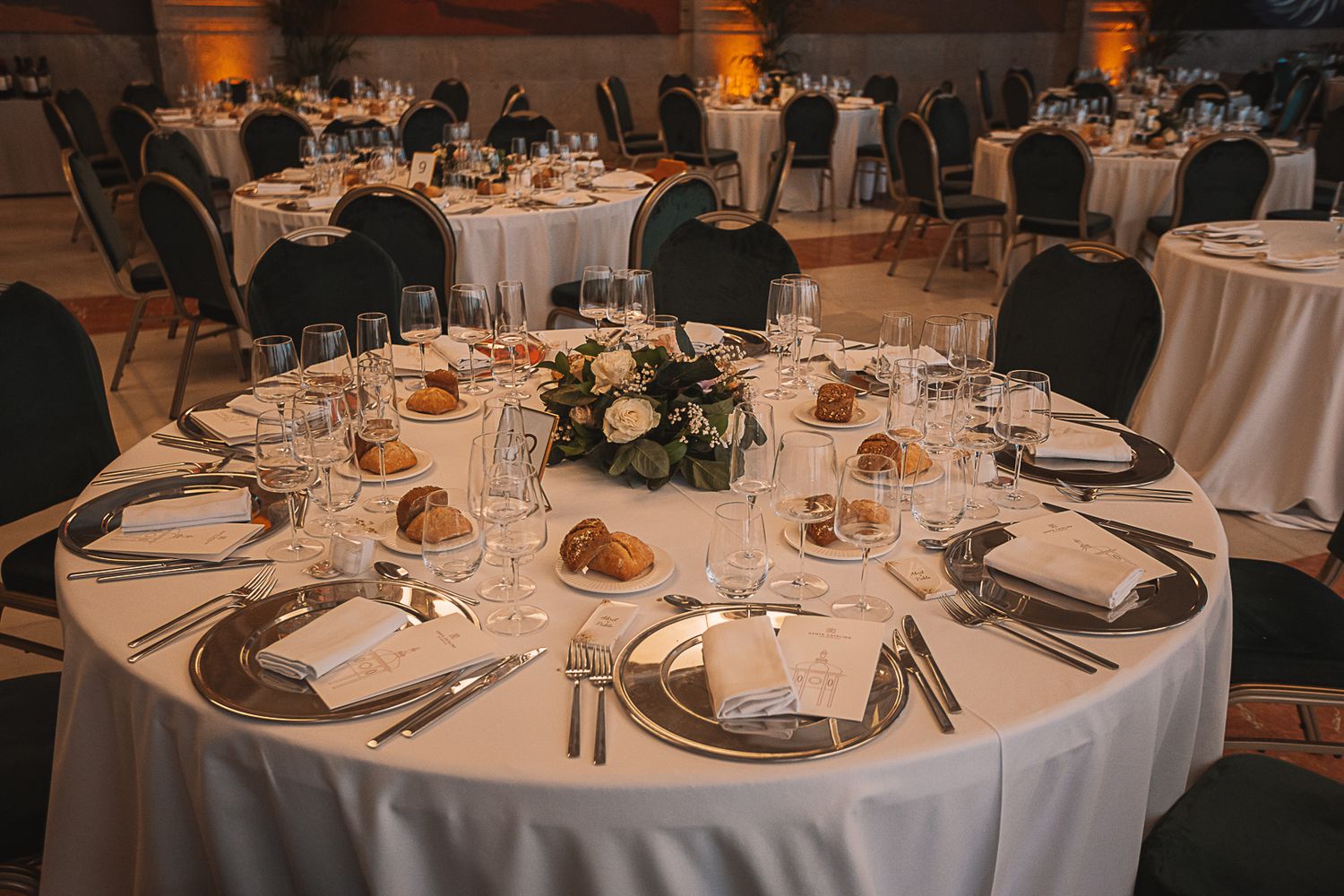 Formal wedding reception tables set with elegant place settings and floral centerpieces.