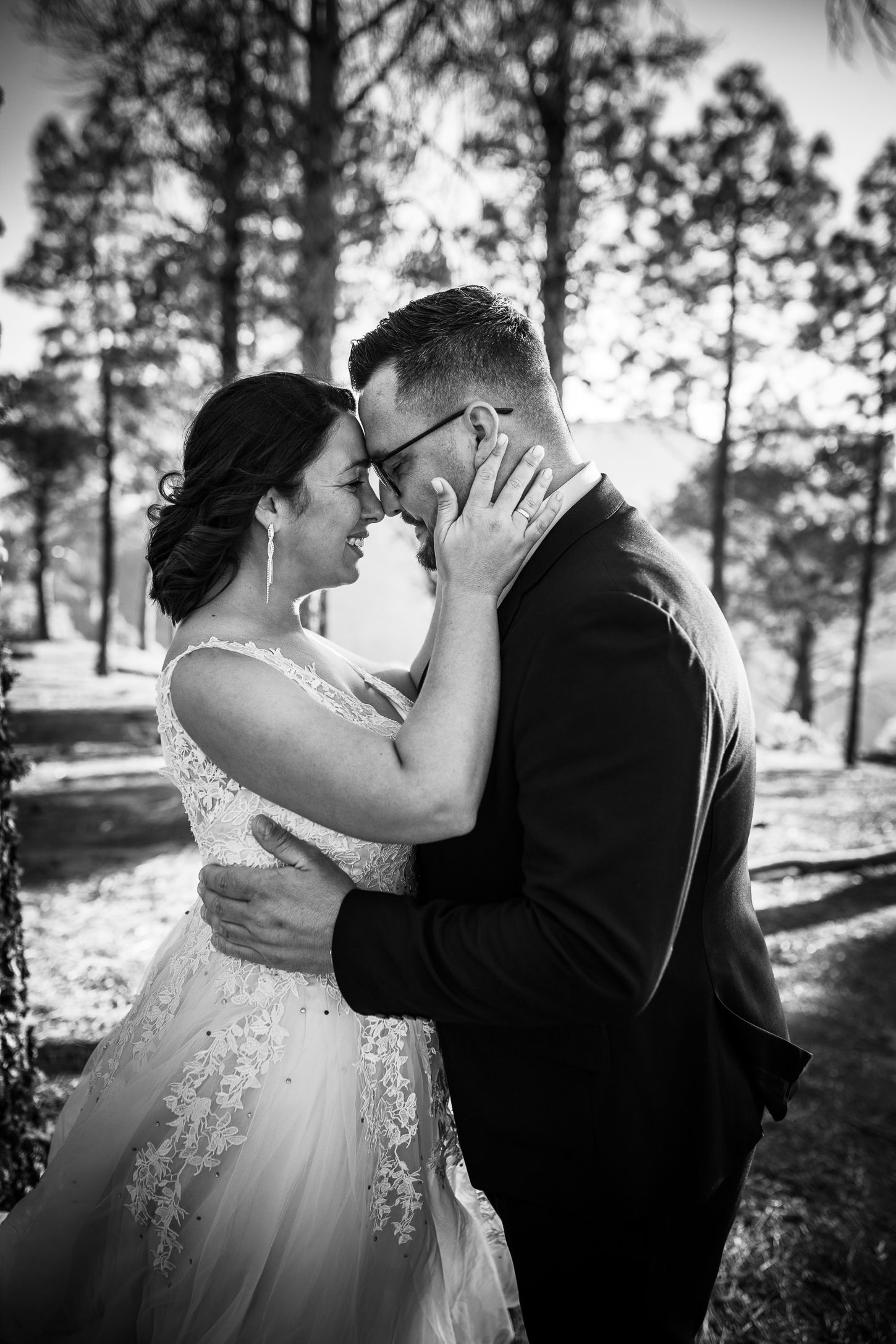 A sequence of black and white wedding kiss photos captured in a pine forest setting.