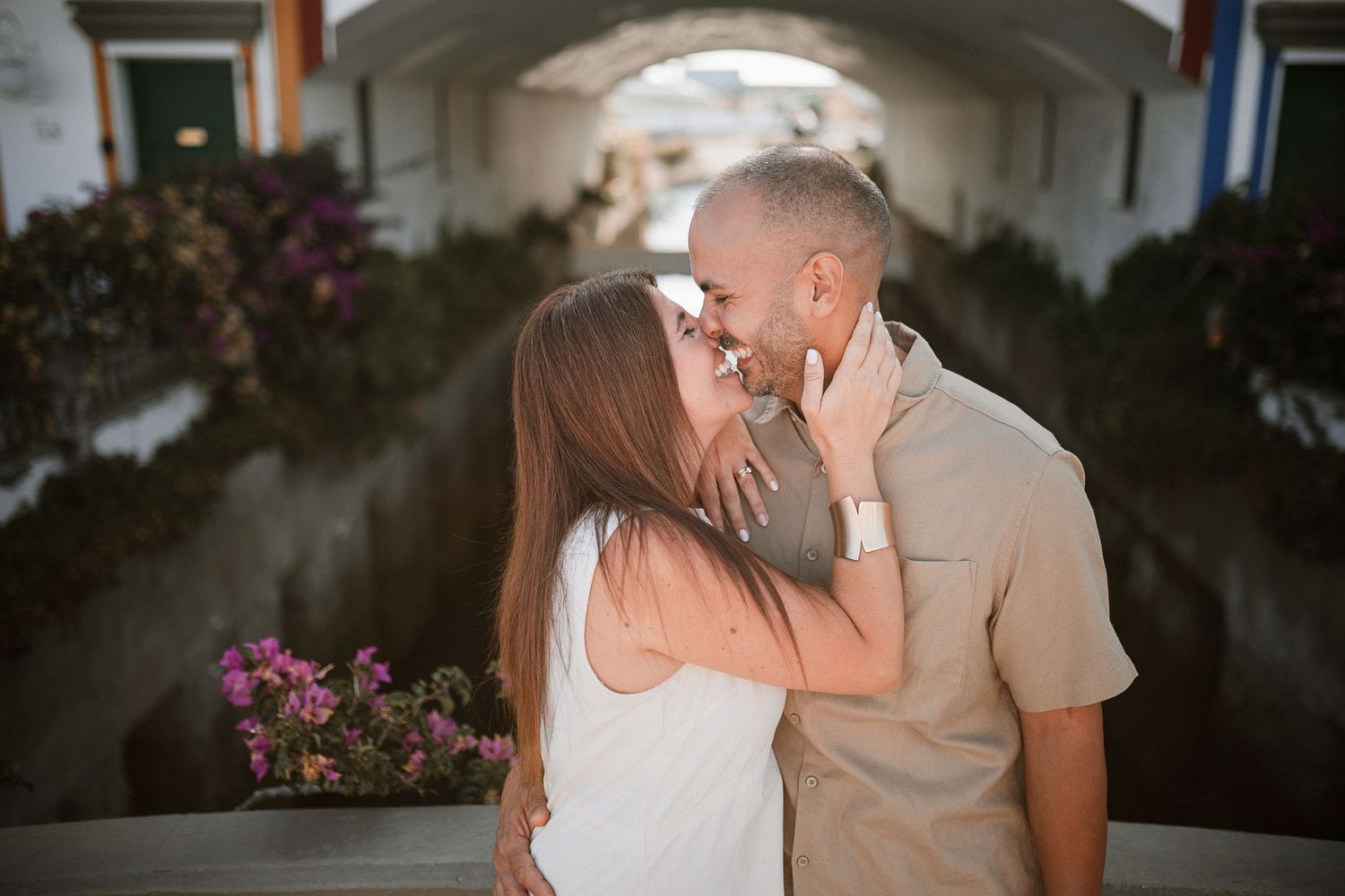 Romantic moment captured in an archway surrounded by blooming bougainvillea.