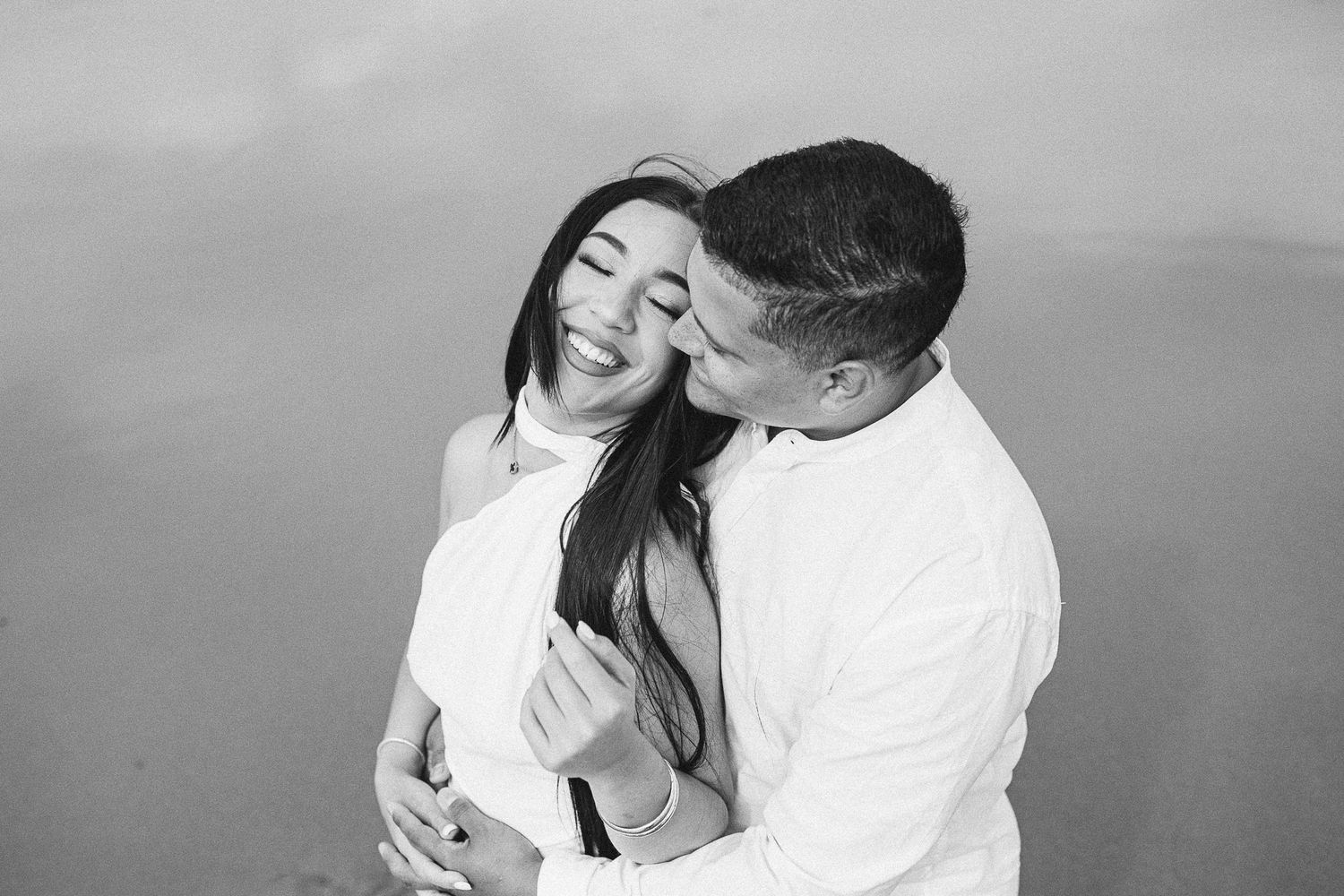 Black and white romantic beach photoshoot with soft lighting.