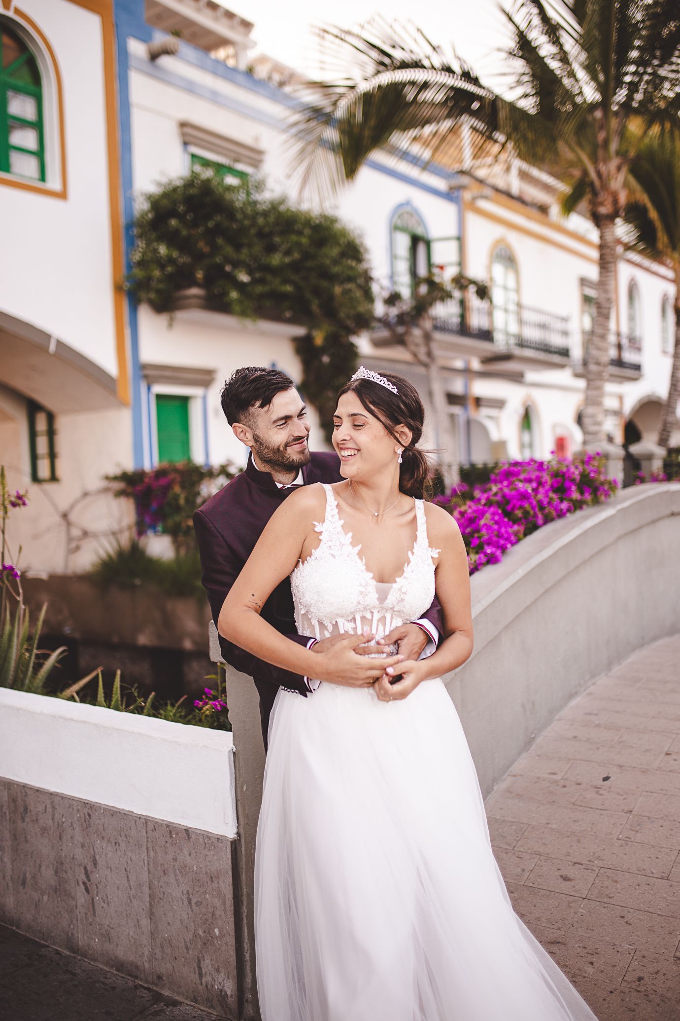 Wedding couple sharing intimate moments along a Mediterranean-style street.