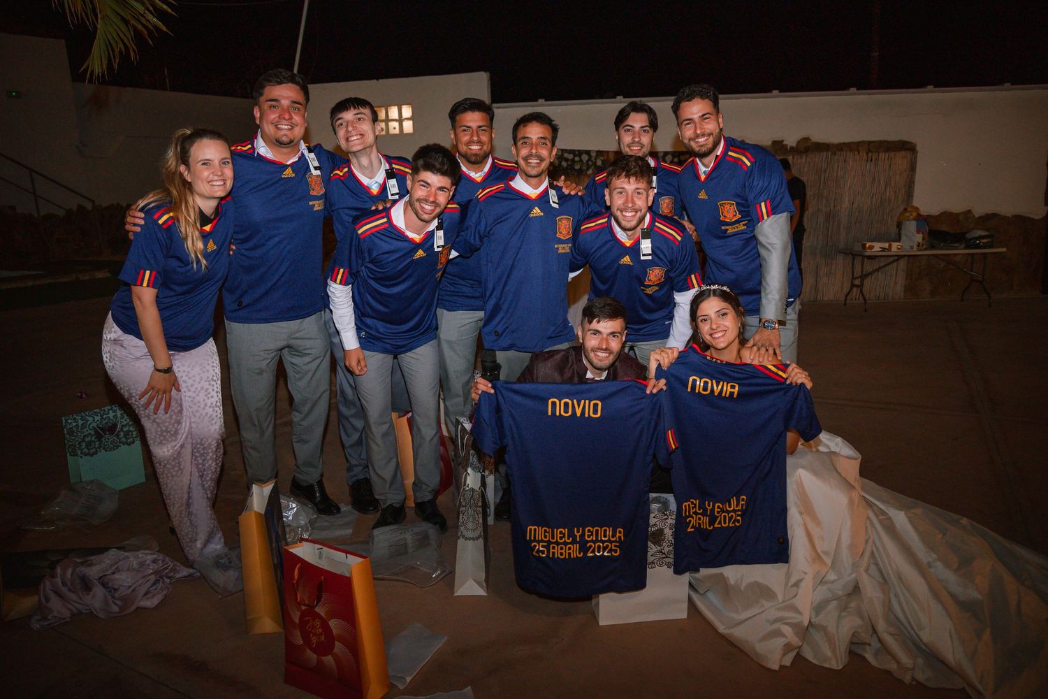 Group wearing matching blue jerseys poses together at an event.