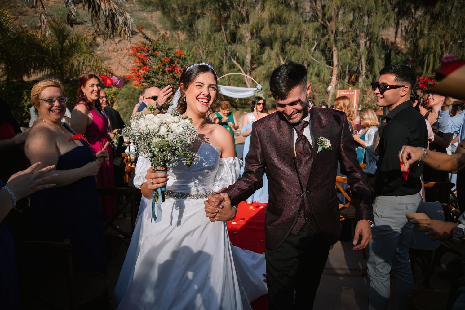 Wedding celebration outdoors with guests dancing and enjoying festivities at sunset.