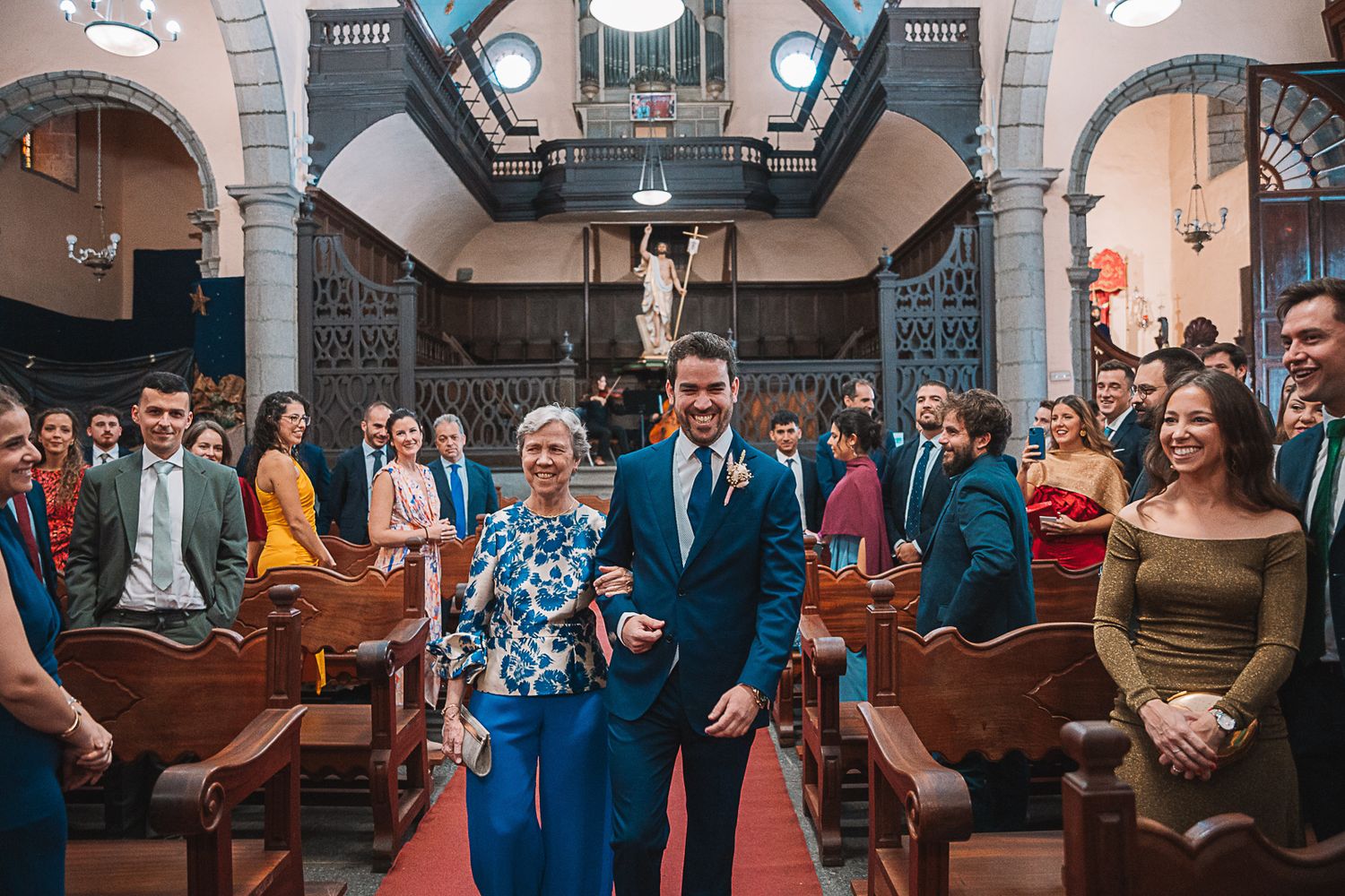 Panoramic view of a church wedding ceremony with guests seated in ornate interior.