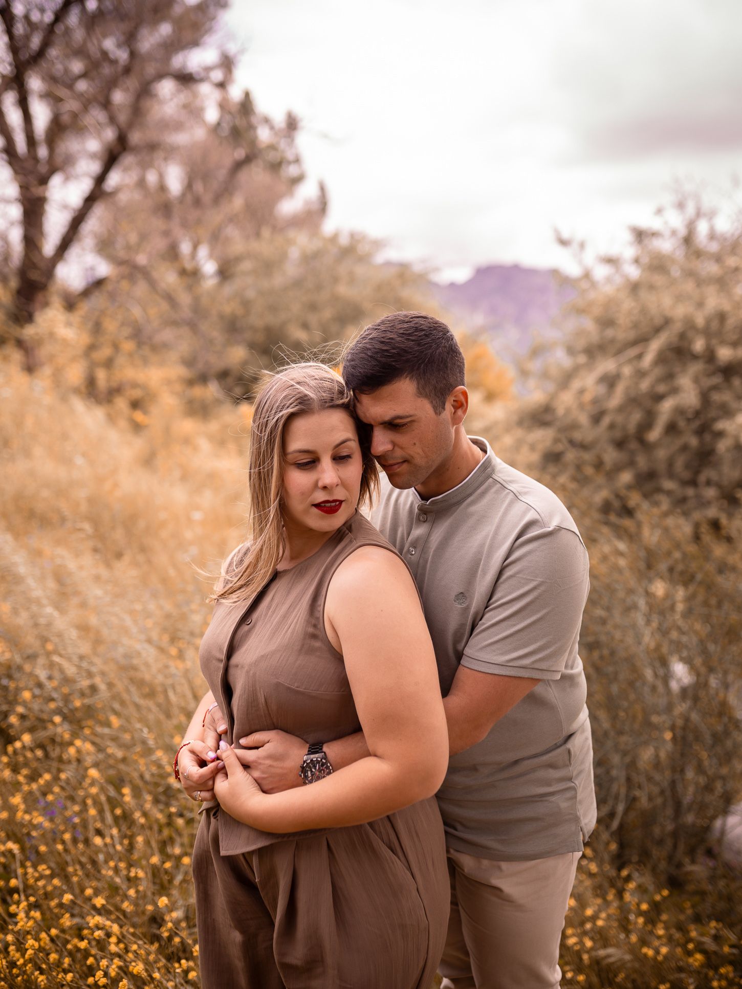 An intimate couple's portrait session in an autumn field with warm golden tones.