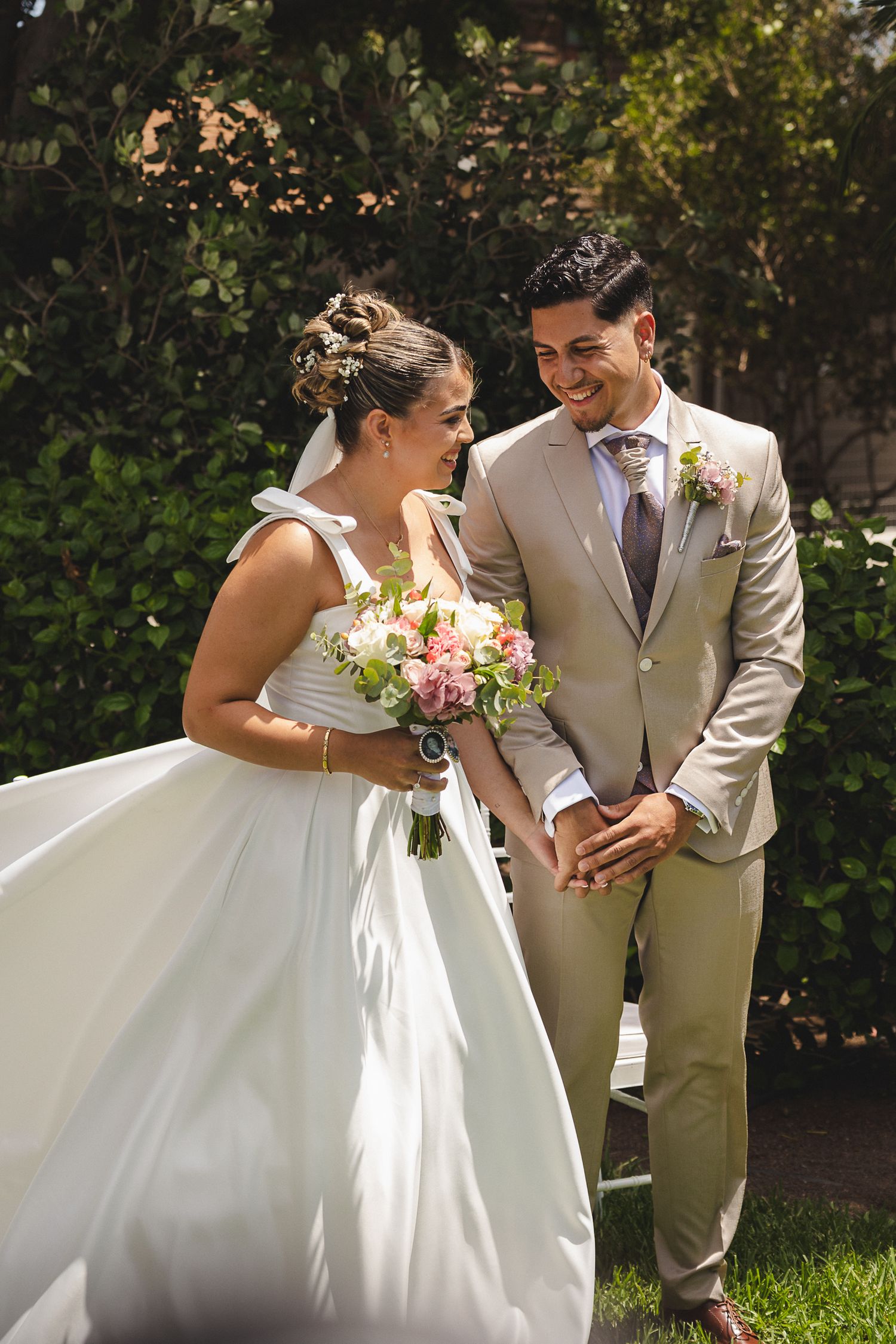 Newlyweds sharing intimate moments in a garden setting.