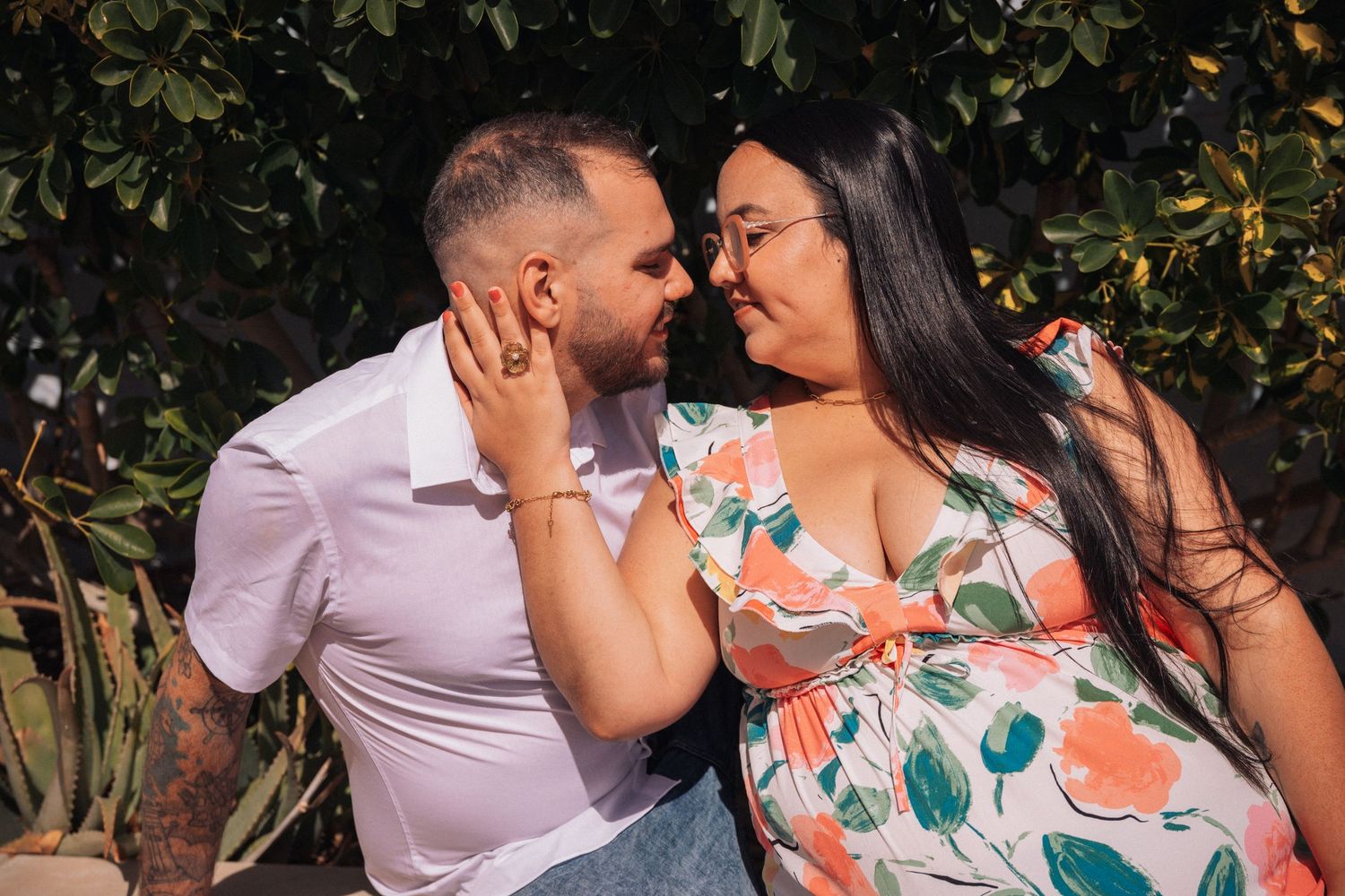 Romantic couple embracing in a lush garden with flowering plants.