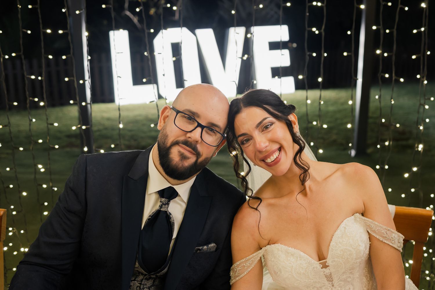 Wedding celebration at night with string lights creating a magical outdoor ambiance.