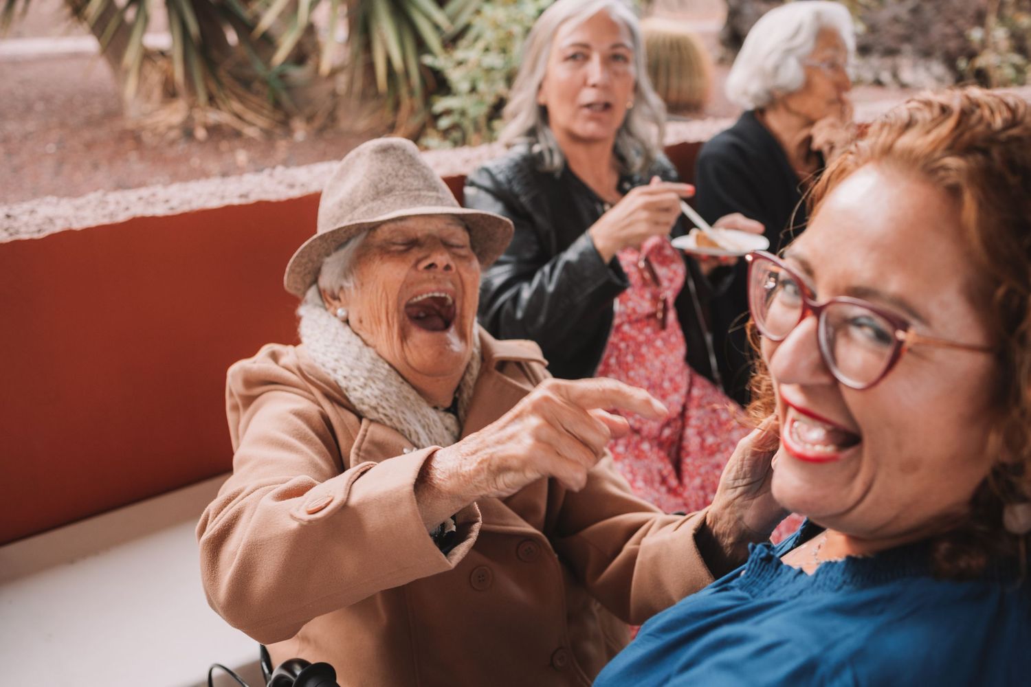 Elderly guests share joyful moments at outdoor celebration venue.