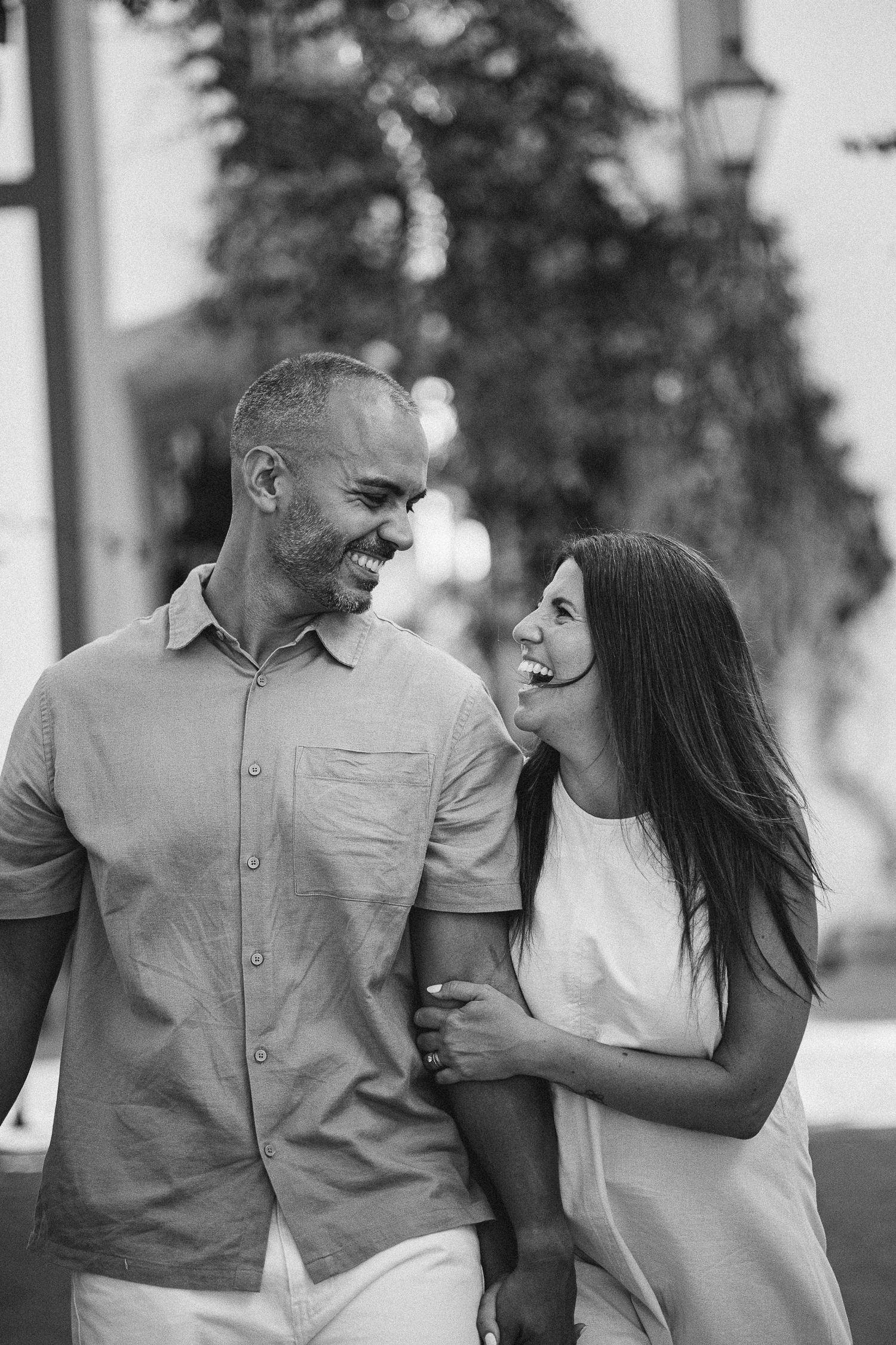 Black and white photos capture a couple's playful and intimate moments while walking together.