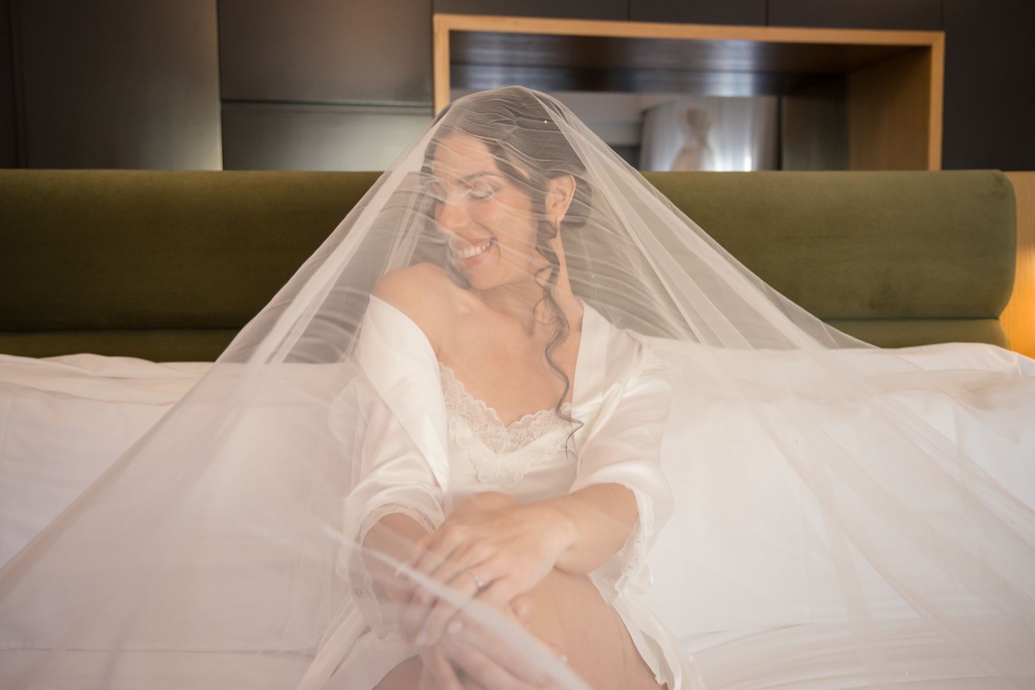 Elegant white wedding veil and dress details laid out on neutral background.