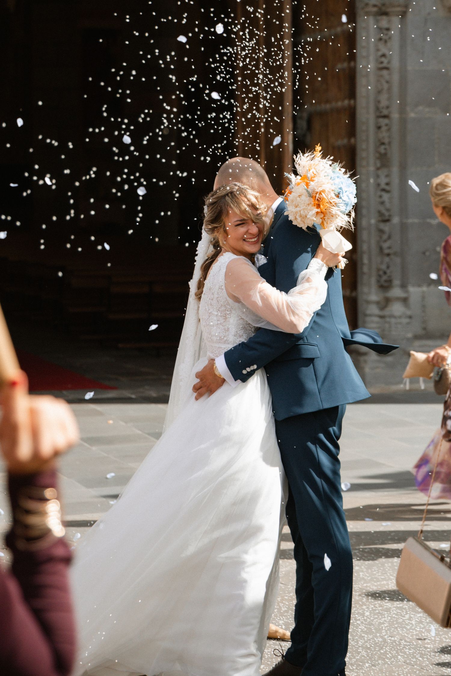 A joyful wedding moment captured with confetti falling around the couple.
