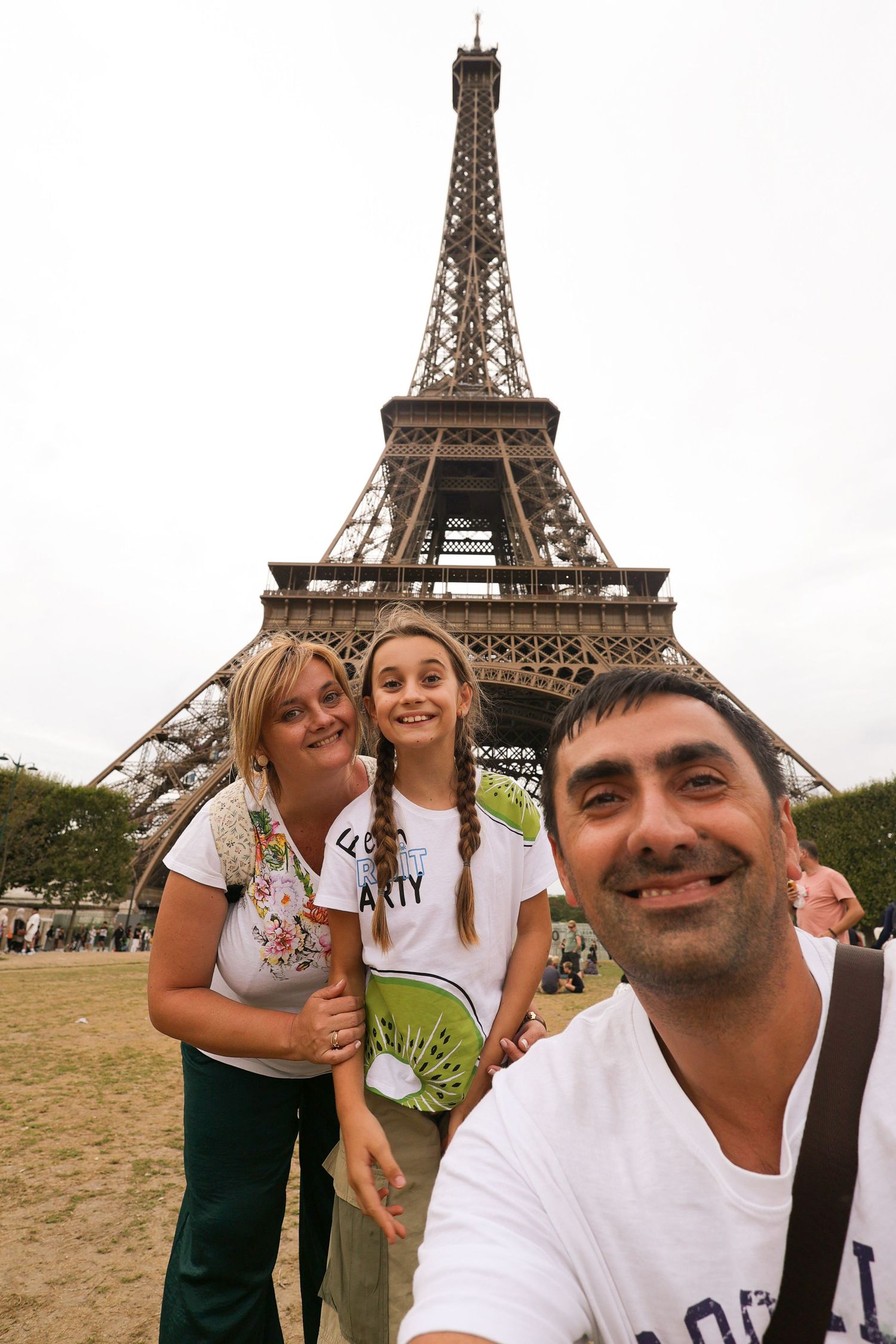 Visitors posing for photos with the iconic Eiffel Tower in the background.