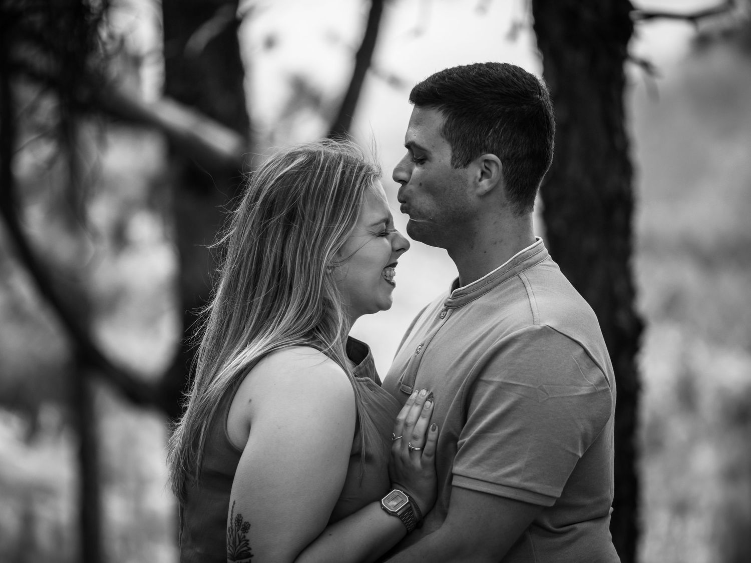 Intimate black and white portrait of a couple in a forest setting.