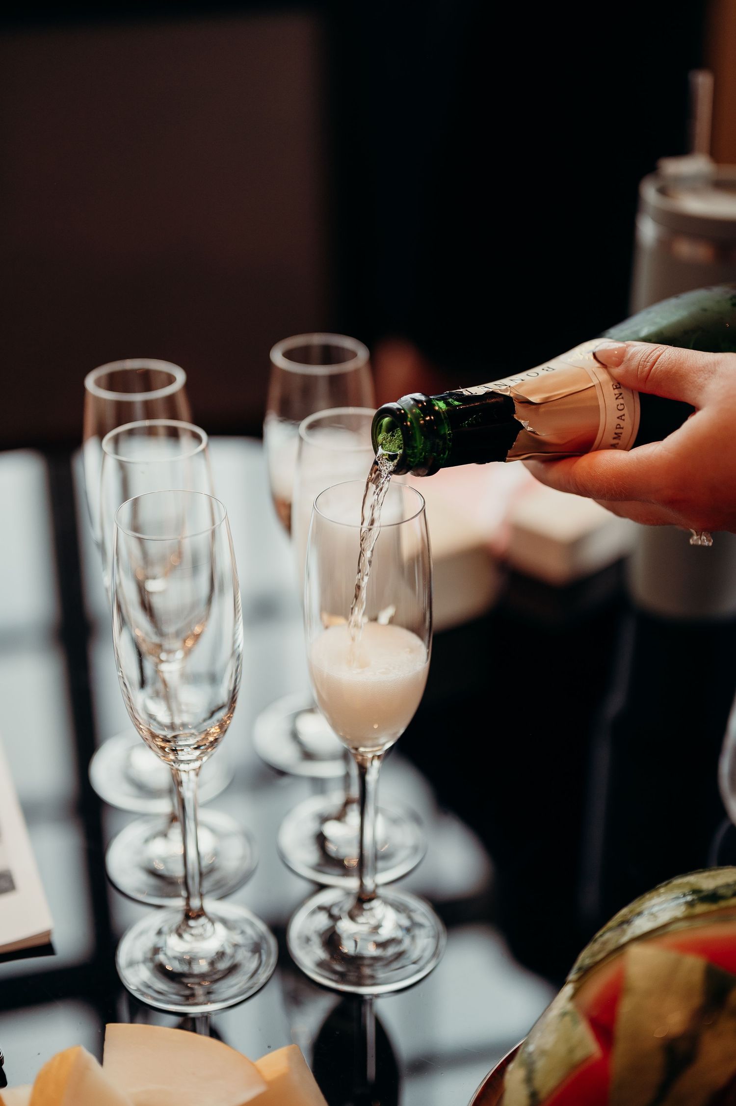 Champagne being poured into elegant flute glasses at a wedding reception.