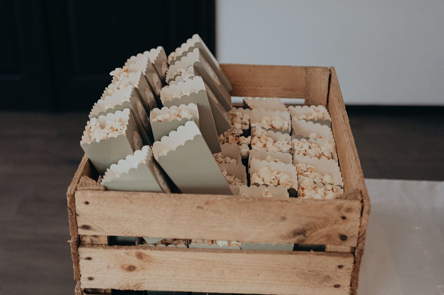 Wooden crate filled with popcorn as wedding favors for guests.