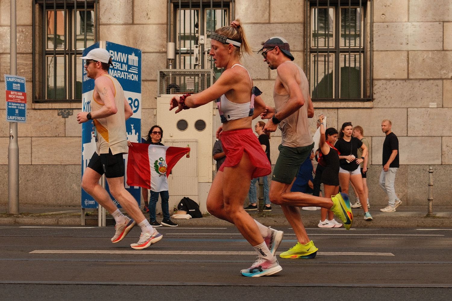 Athletes racing past classical architecture during a city marathon event.