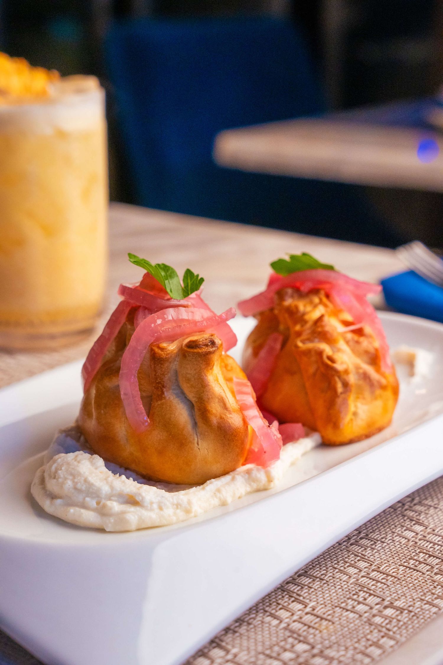 Baked pastry puffs filled with cream served on white plate with garnish.