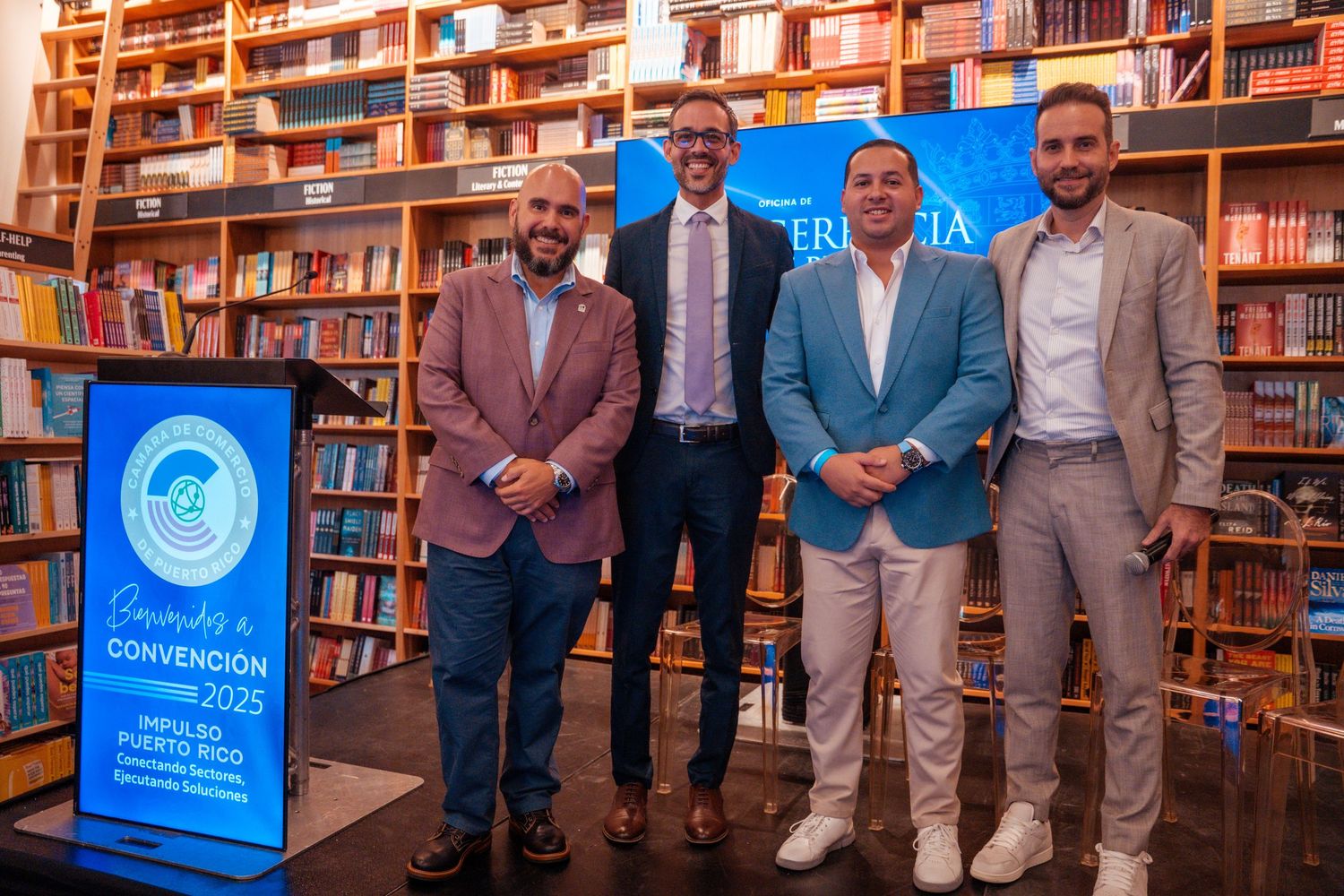 Group photo of event participants standing in front of library shelves with promotional banners.