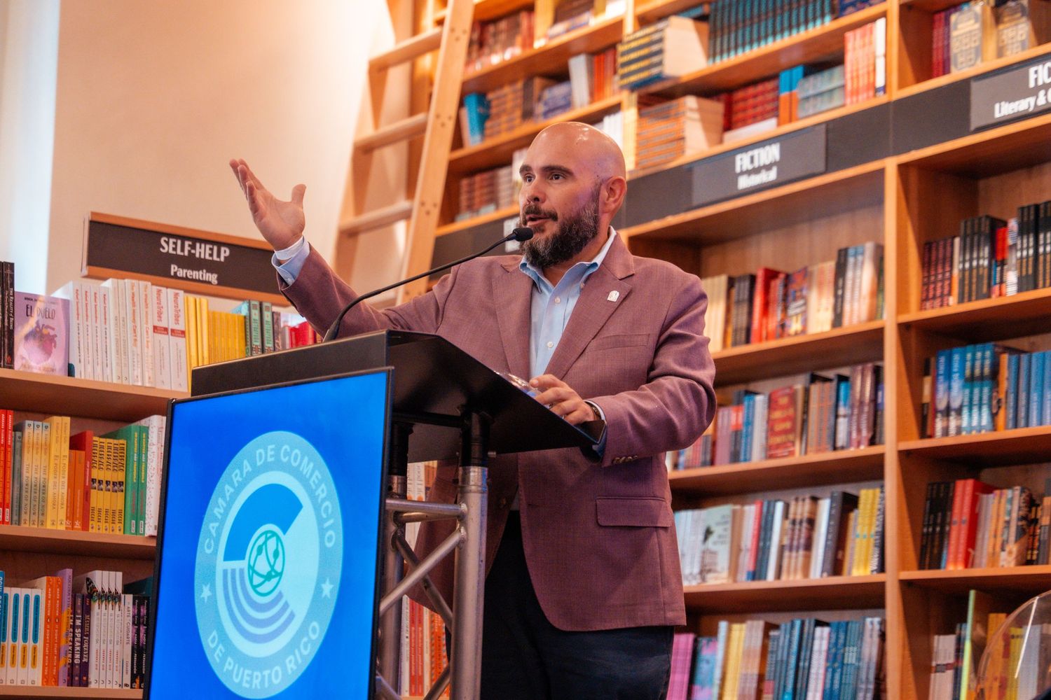 Speakers engaging in conversation during a presentation at a bookstore with illuminated signage.