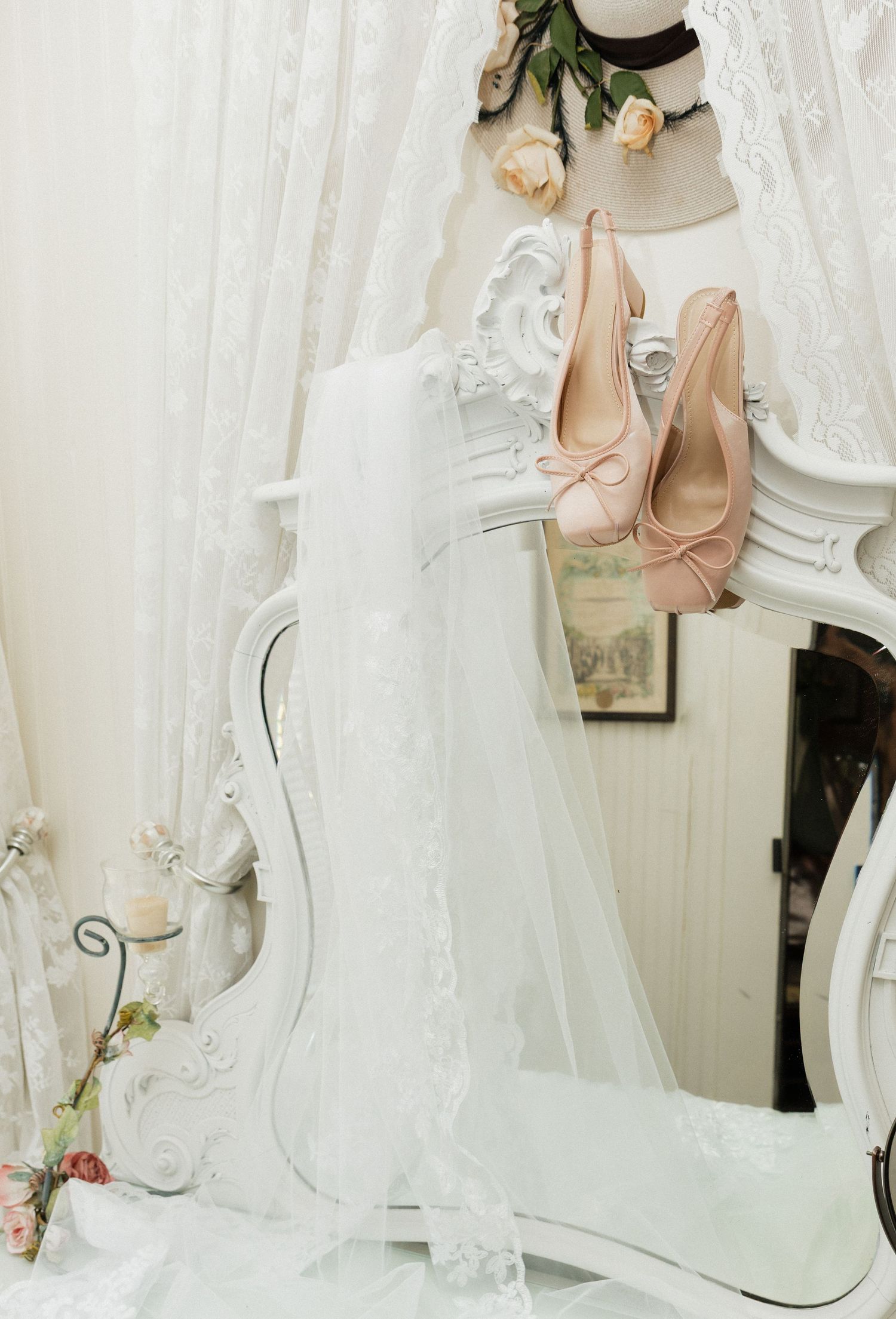 Wedding dresses and bridal accessories displayed in an elegant white boutique with ornate mirrors and lace details.