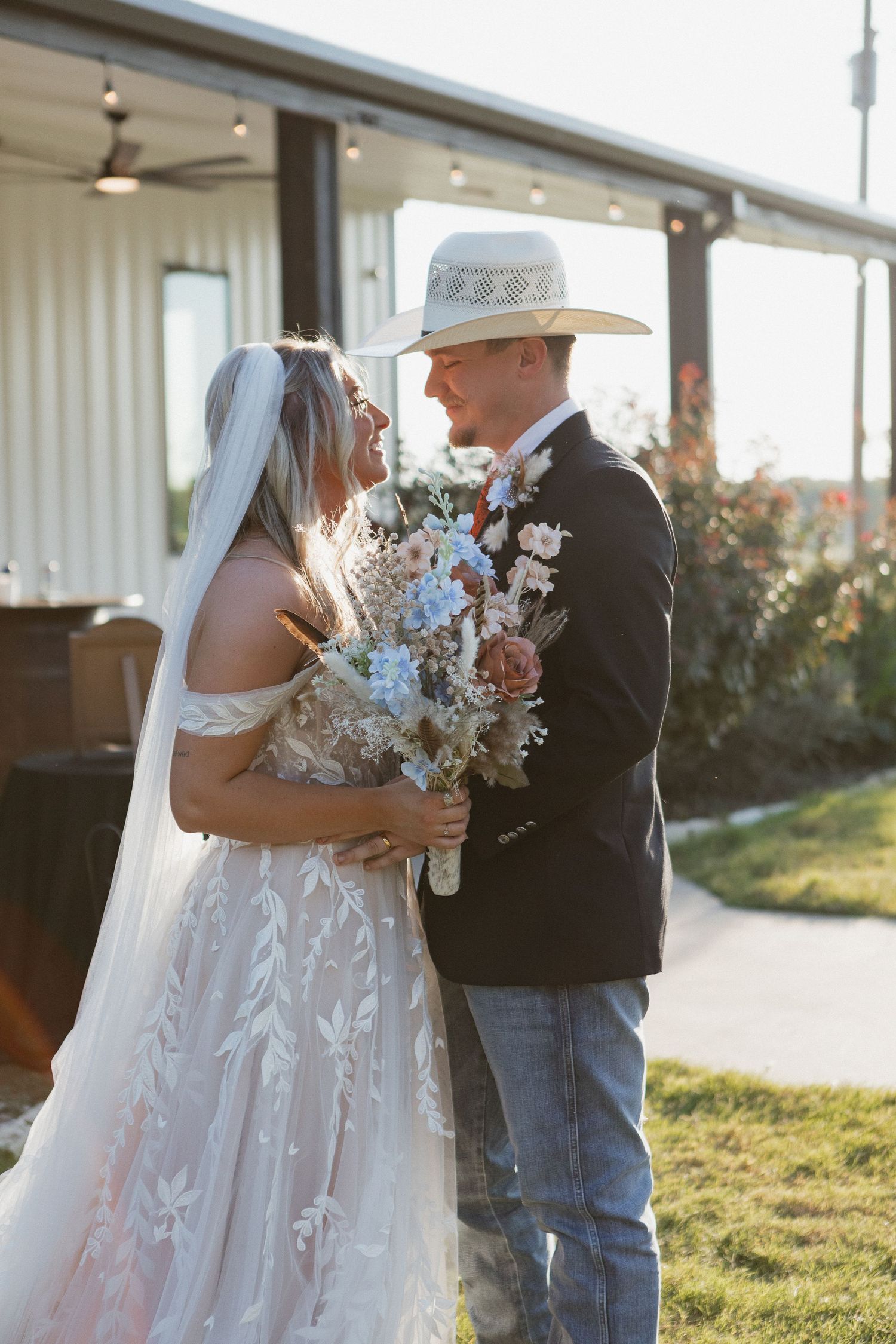 Romantic outdoor wedding portraits at sunset with rustic barn backdrop.
