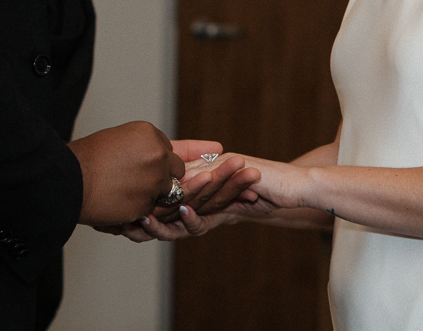 Close-up sequence of hands exchanging rings during a wedding ceremony.
