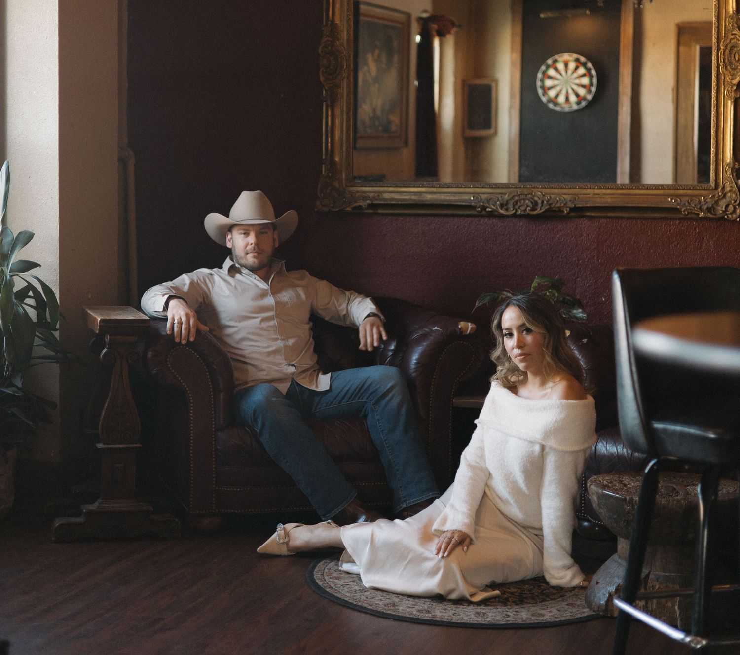 A series of five connected photos showing a person in white clothing lounging on various pieces of furniture in a dimly lit room.