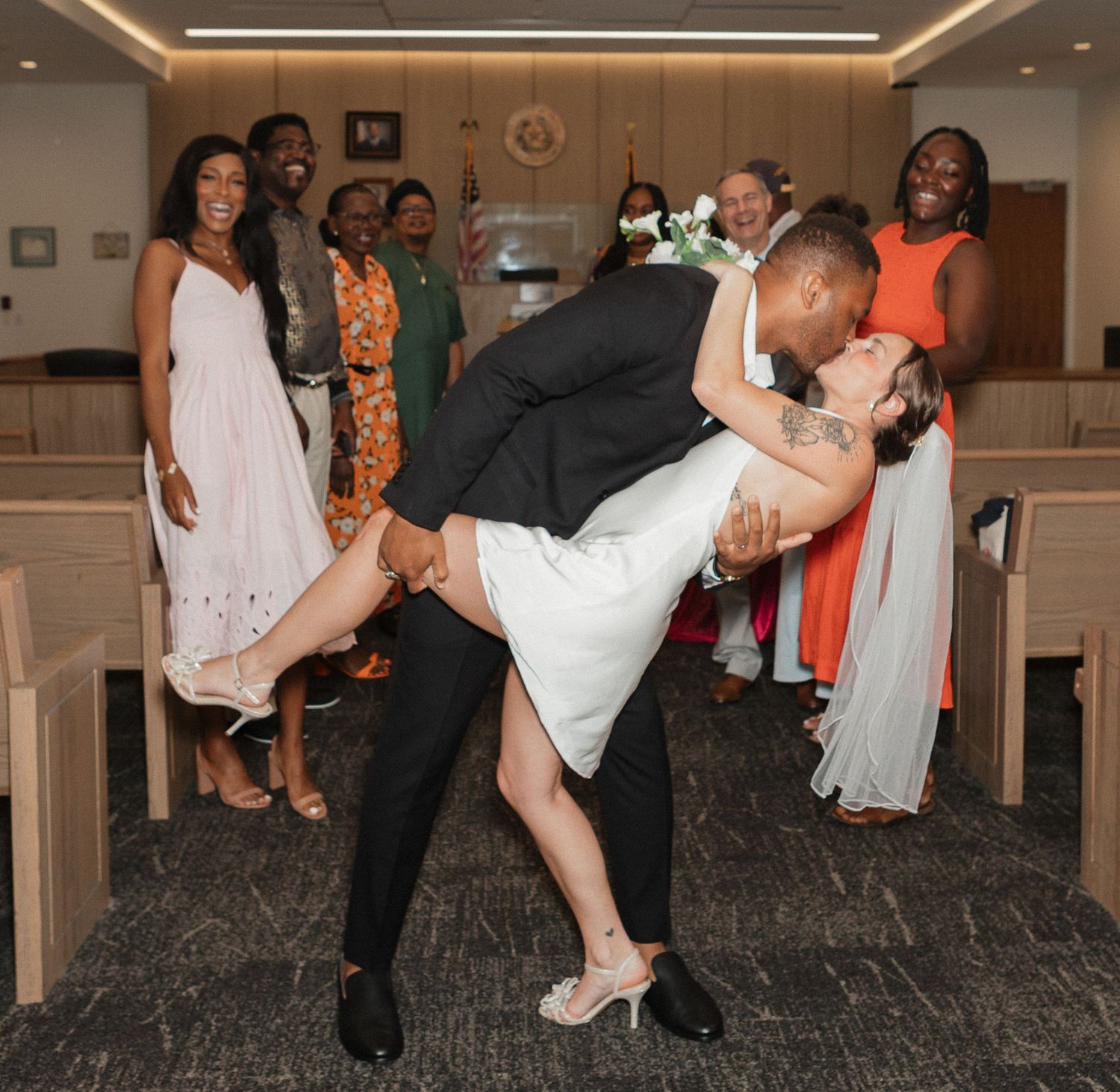 Couples dancing and dipping during wedding reception in indoor venue.