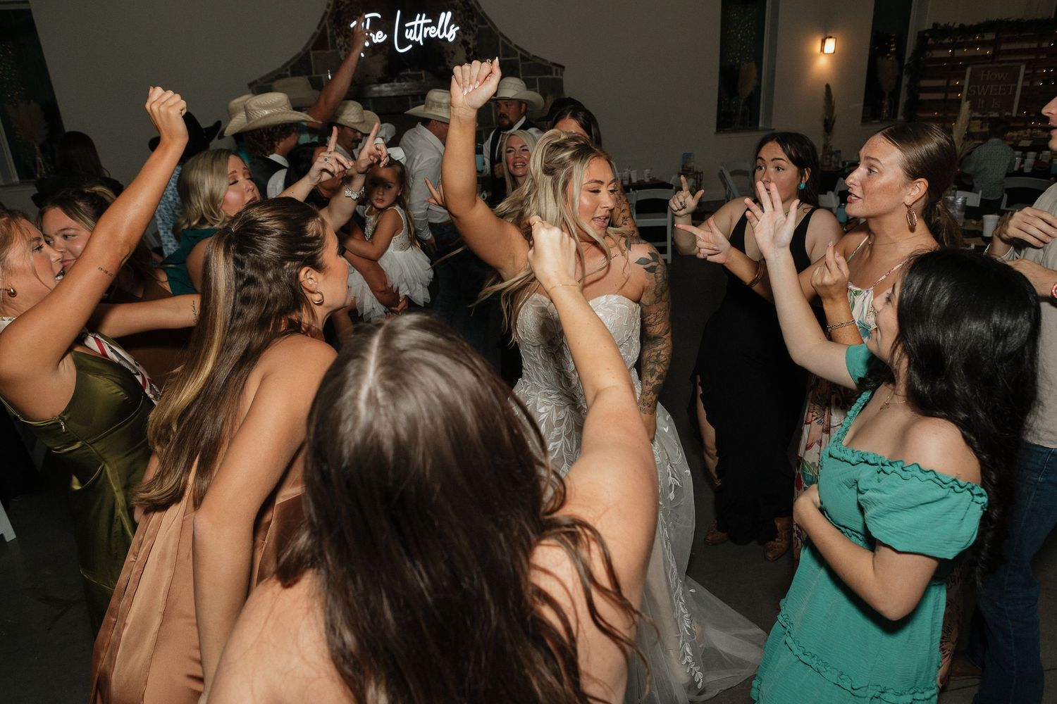 Wedding reception dance party with guests celebrating on dance floor.