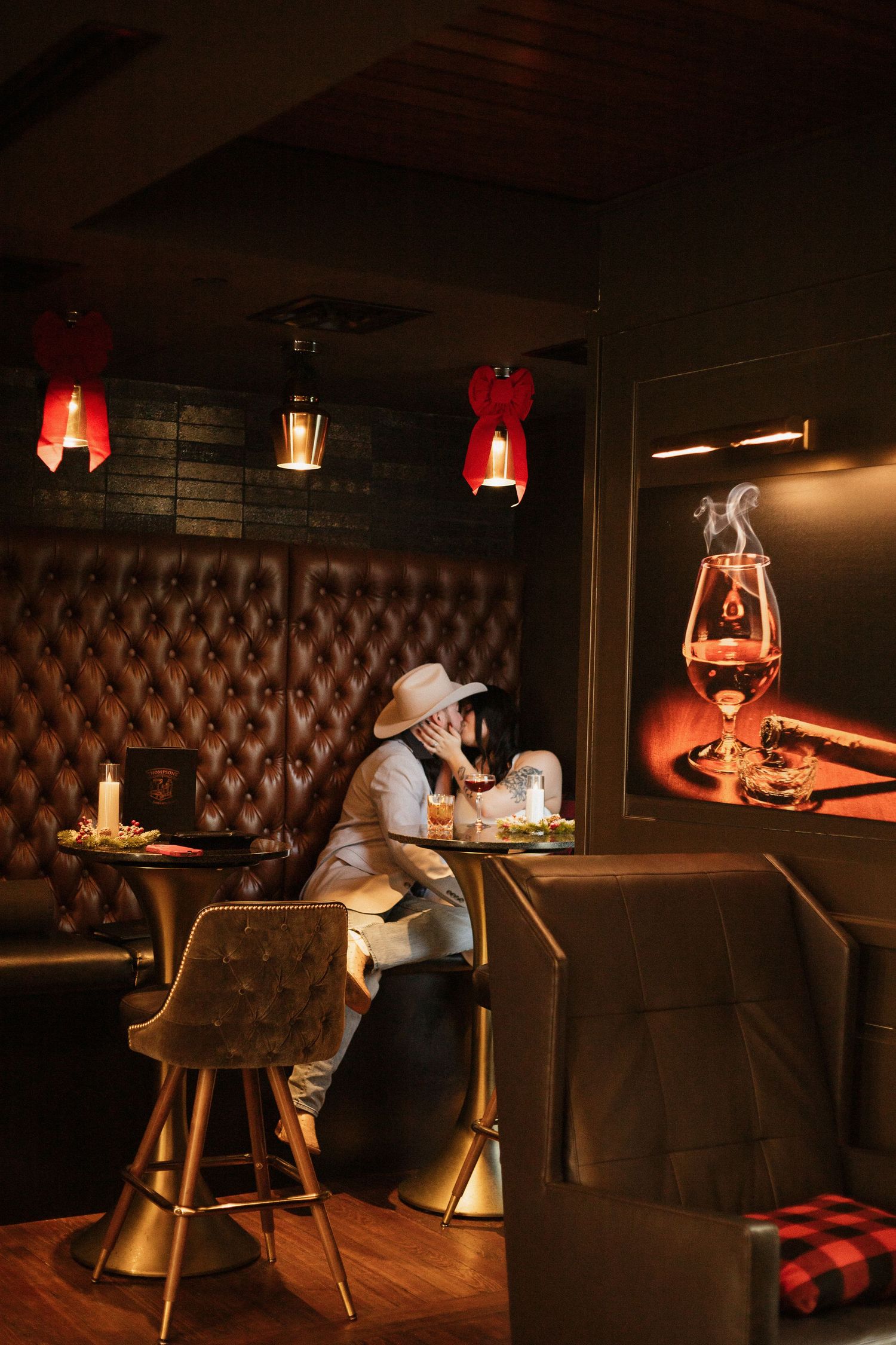 Moody bar scene with leather booths and red lighting creating romantic ambiance.