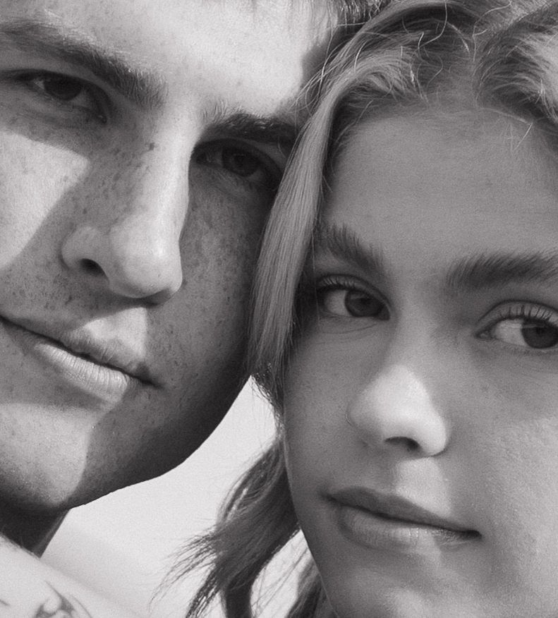 Black and white close-up portrait of two young people with freckles looking at the camera.