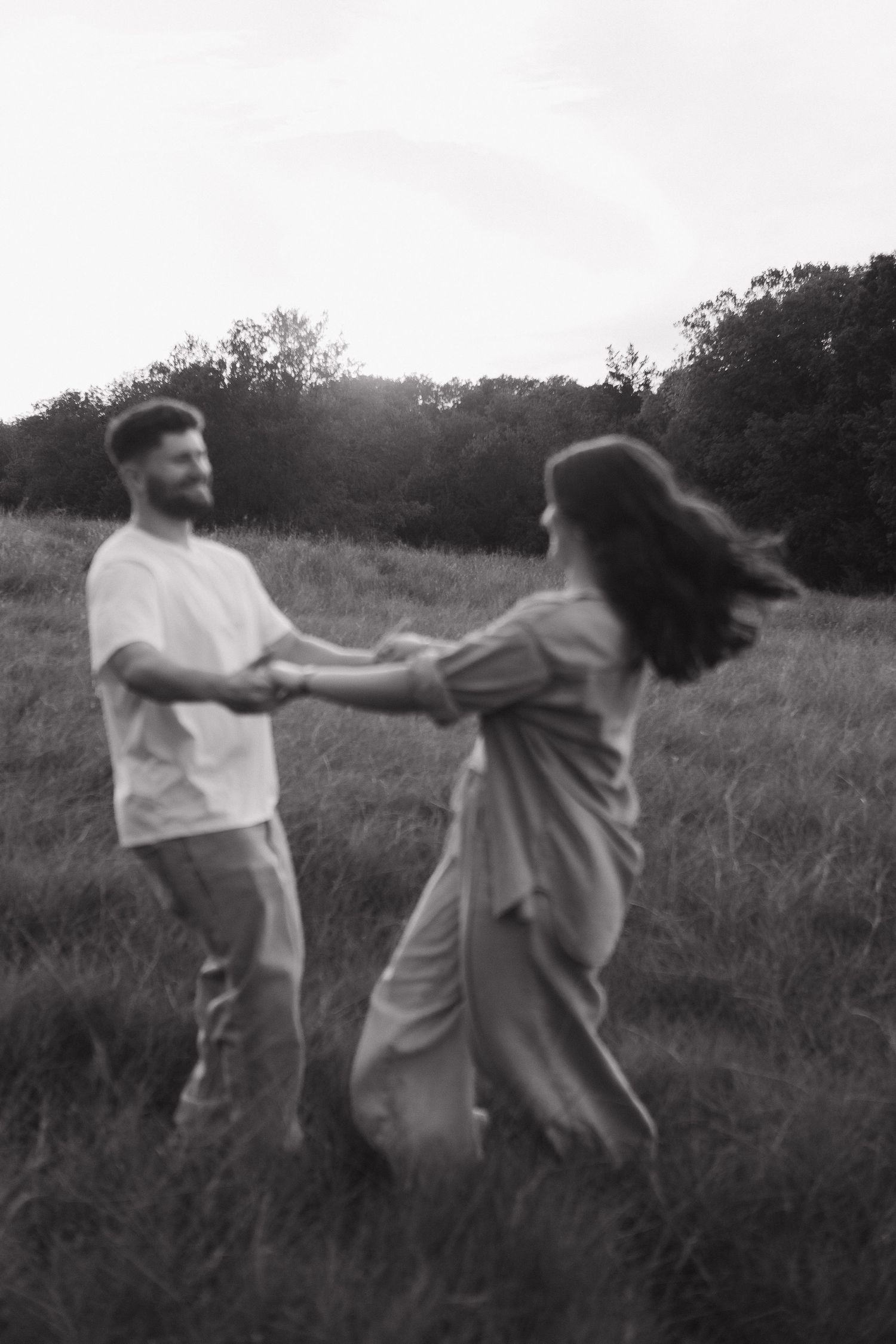 A couple dances together in a grassy field, captured in a sequence of black and white photos showing spinning movement Mckinney, Texas