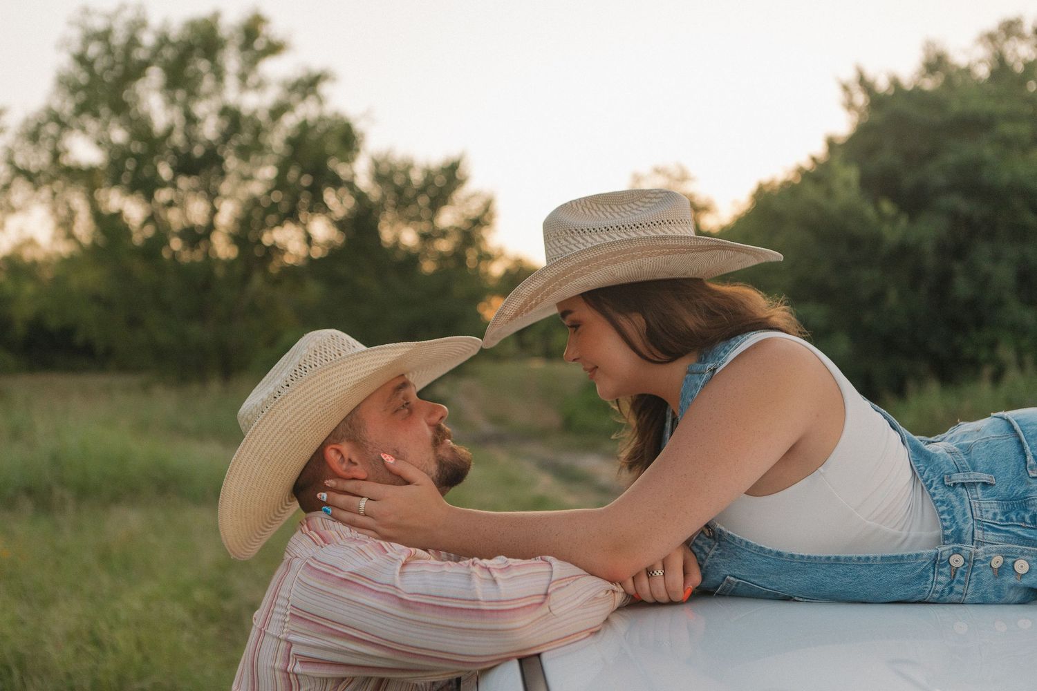 A western couple posing on and in a truck in Caddo Mills Texas