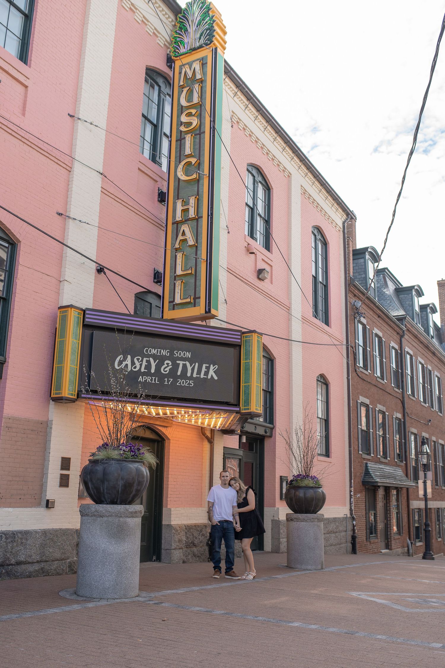 A couple poses under a Music Hall marquee sign reading Casey and Tyler April 17 2025.