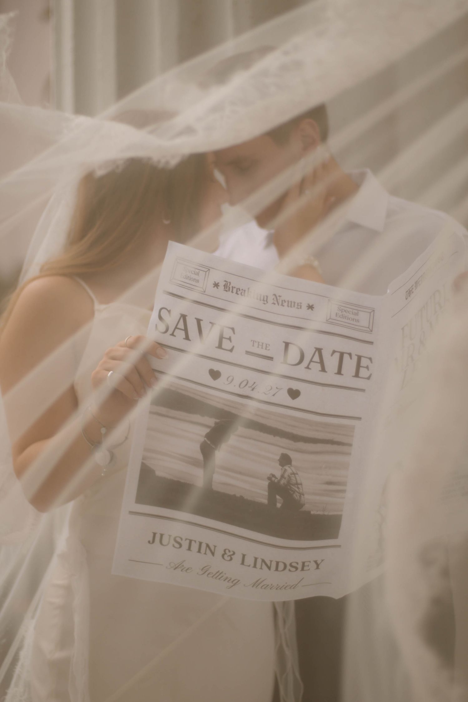 Wedding save the date invitation cards photographed through delicate white veil fabric.