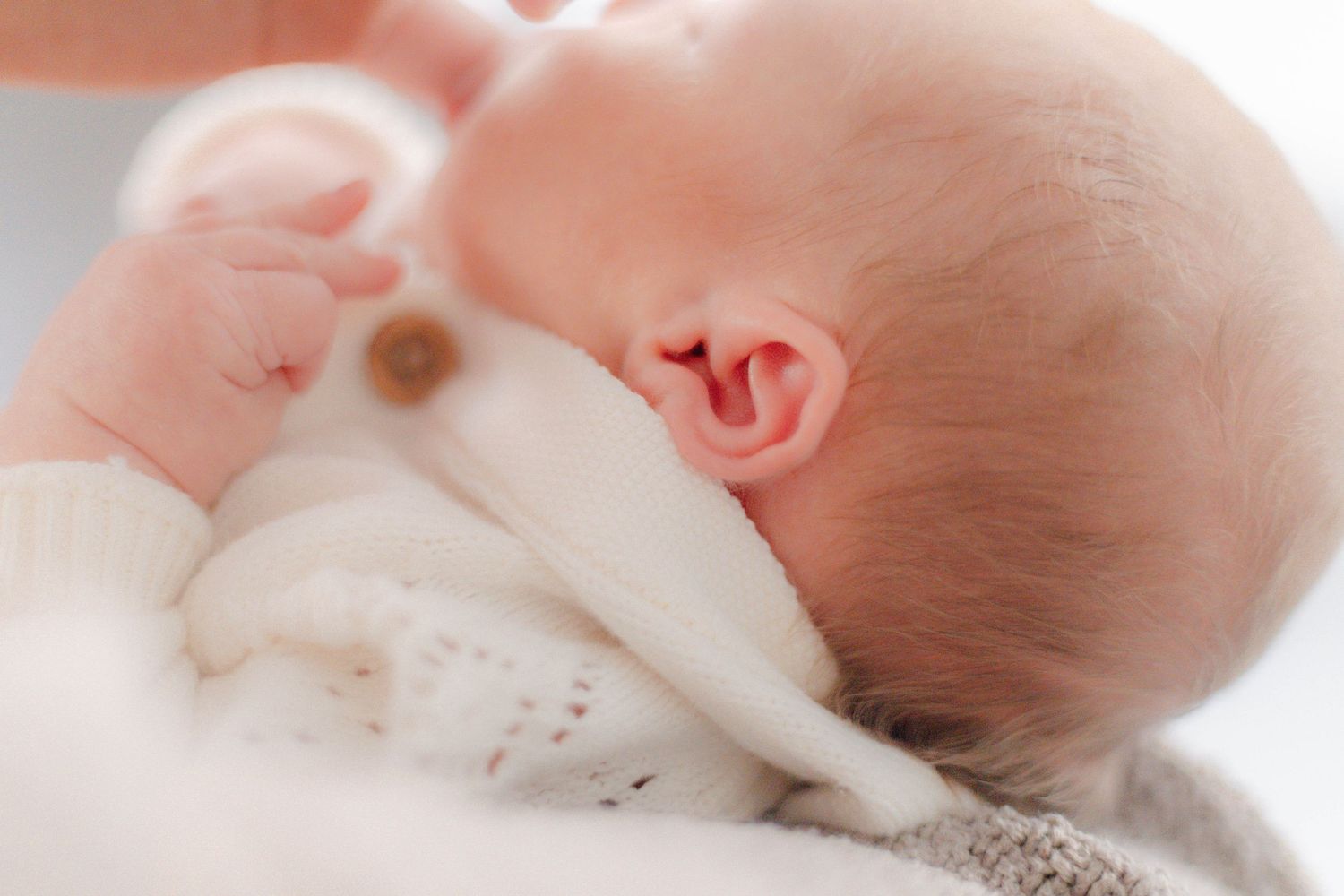 Close-up view of a sleeping newborn baby in soft natural lighting.