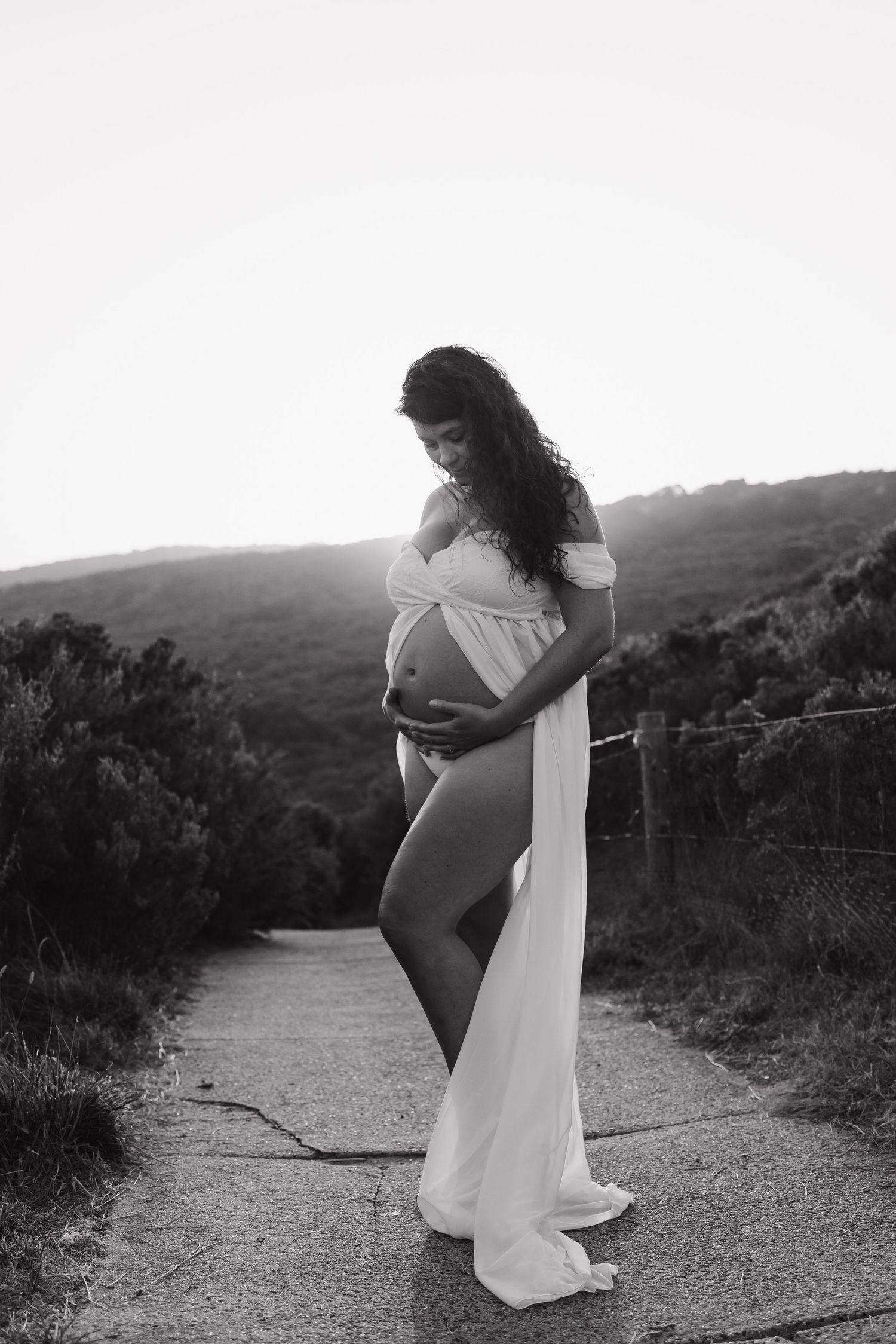 Artistic black and white maternity photos on a mountain path.