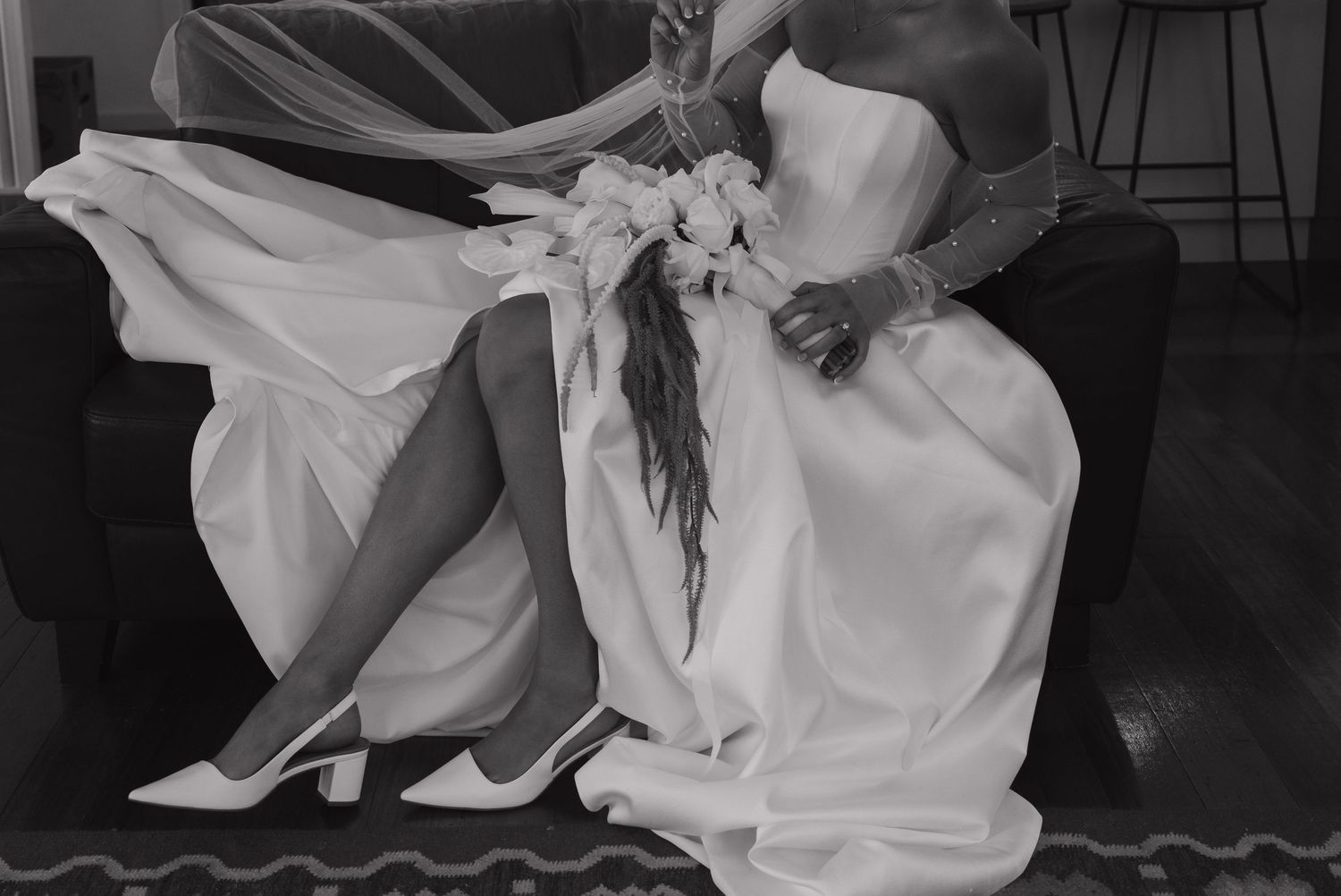 Black and white photo of a bride's dress and shoes in an artistic composition.