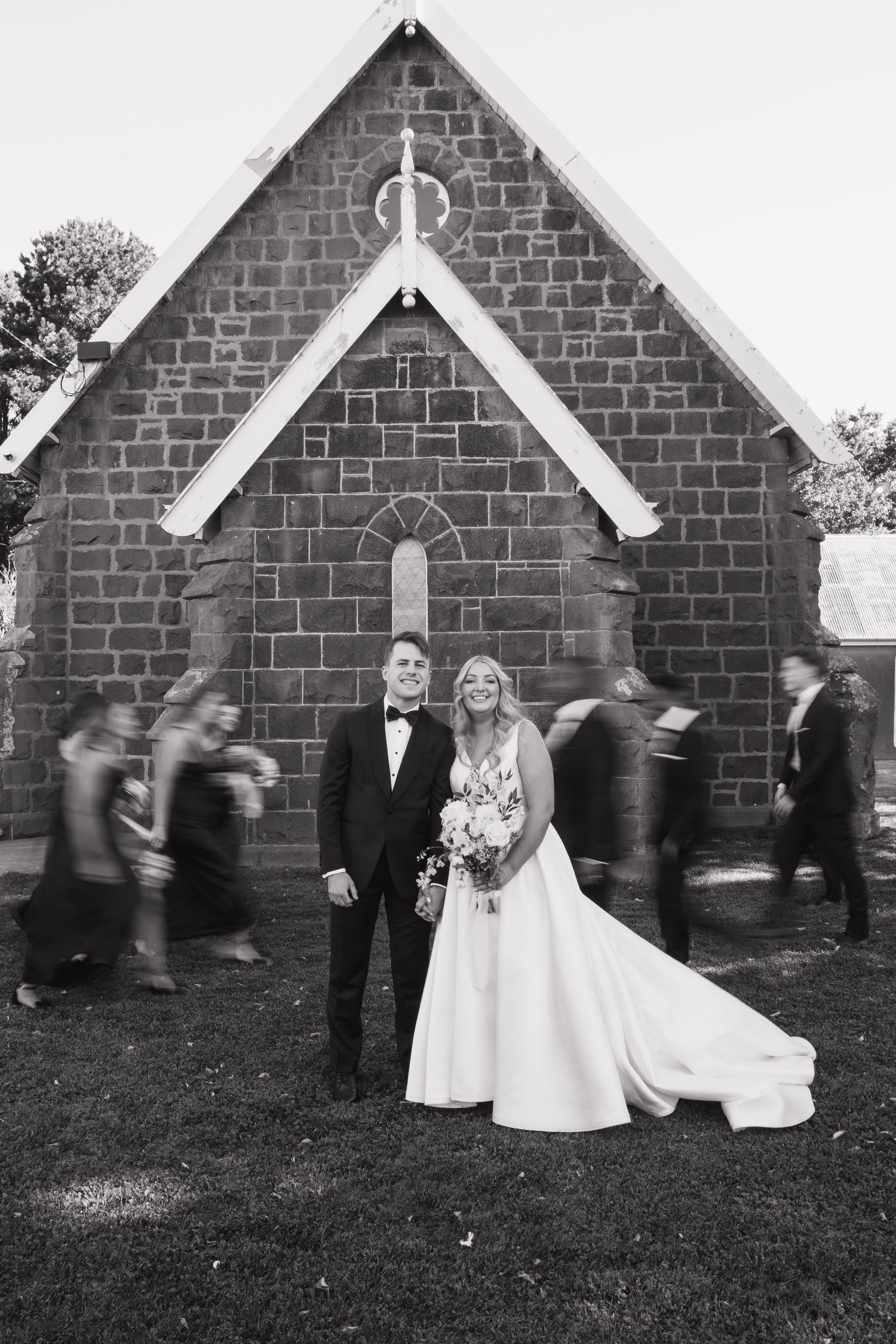 Wedding party posed against brick building with motion blur effect.