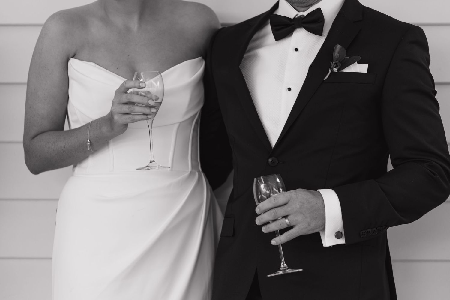 Formal wedding portrait showing details of classic black tie and white dress attire.
